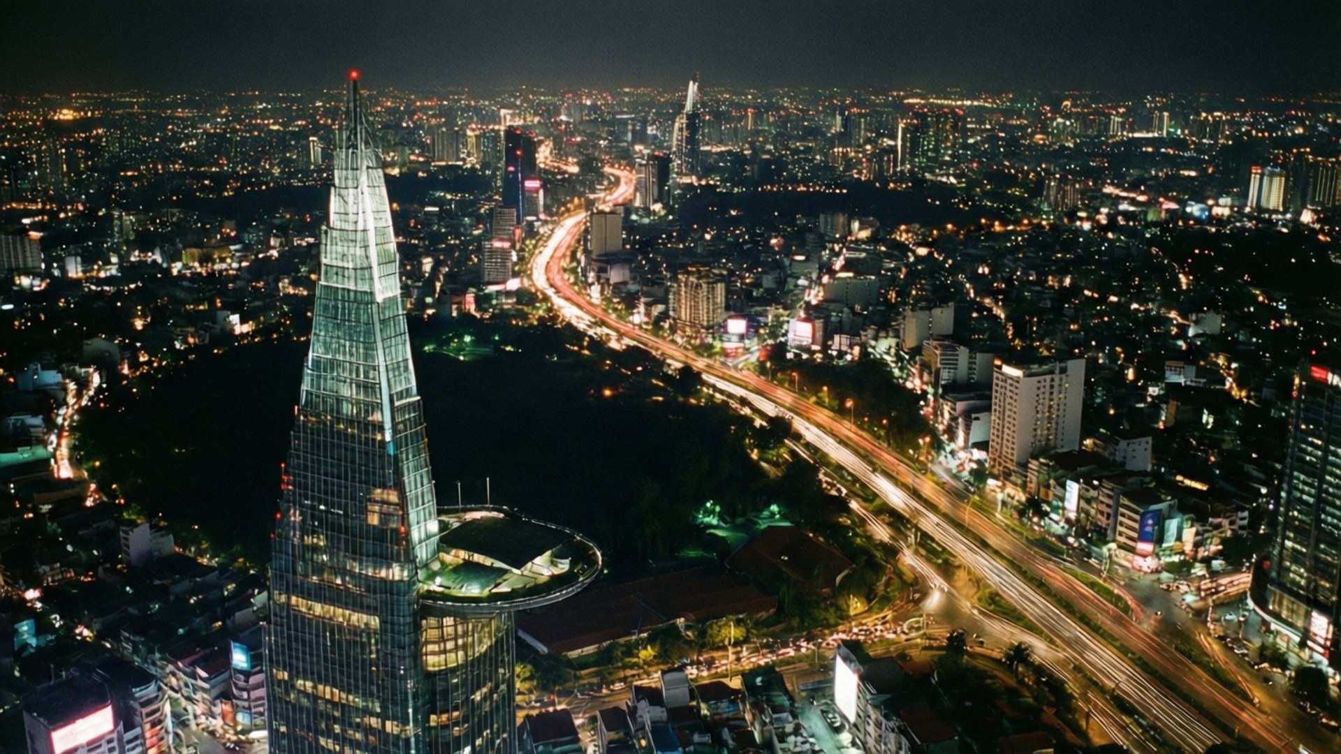 Skydeck City Lights 壁紙 — 現代城市景觀的空中夜景，以帶有尖頂和發光燈光的玻璃摩天大樓為主導。