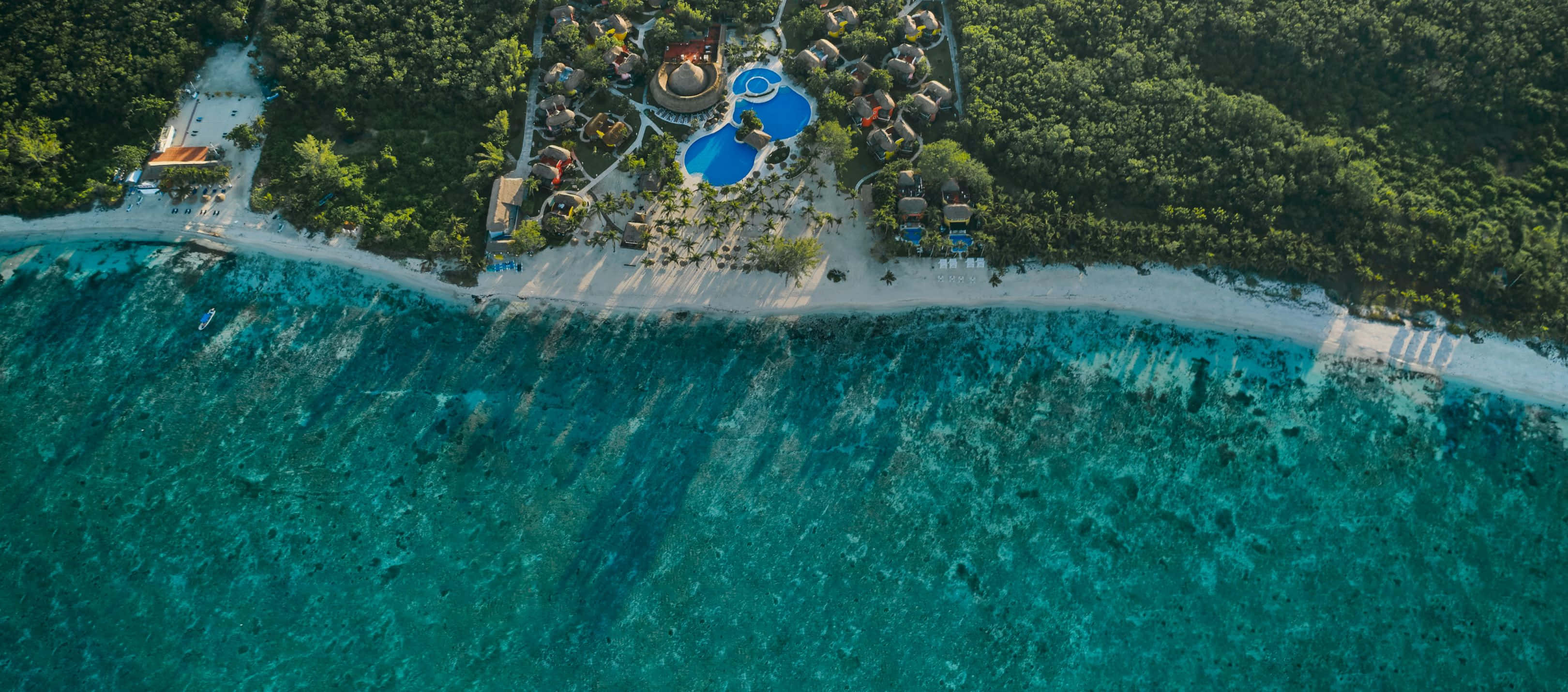 Beach Resort 桌布 壁紙 — 豪華度假村坐落在白色沙灘上的鳥瞰圖，擁有碧綠的海水和茂密的綠色叢林。