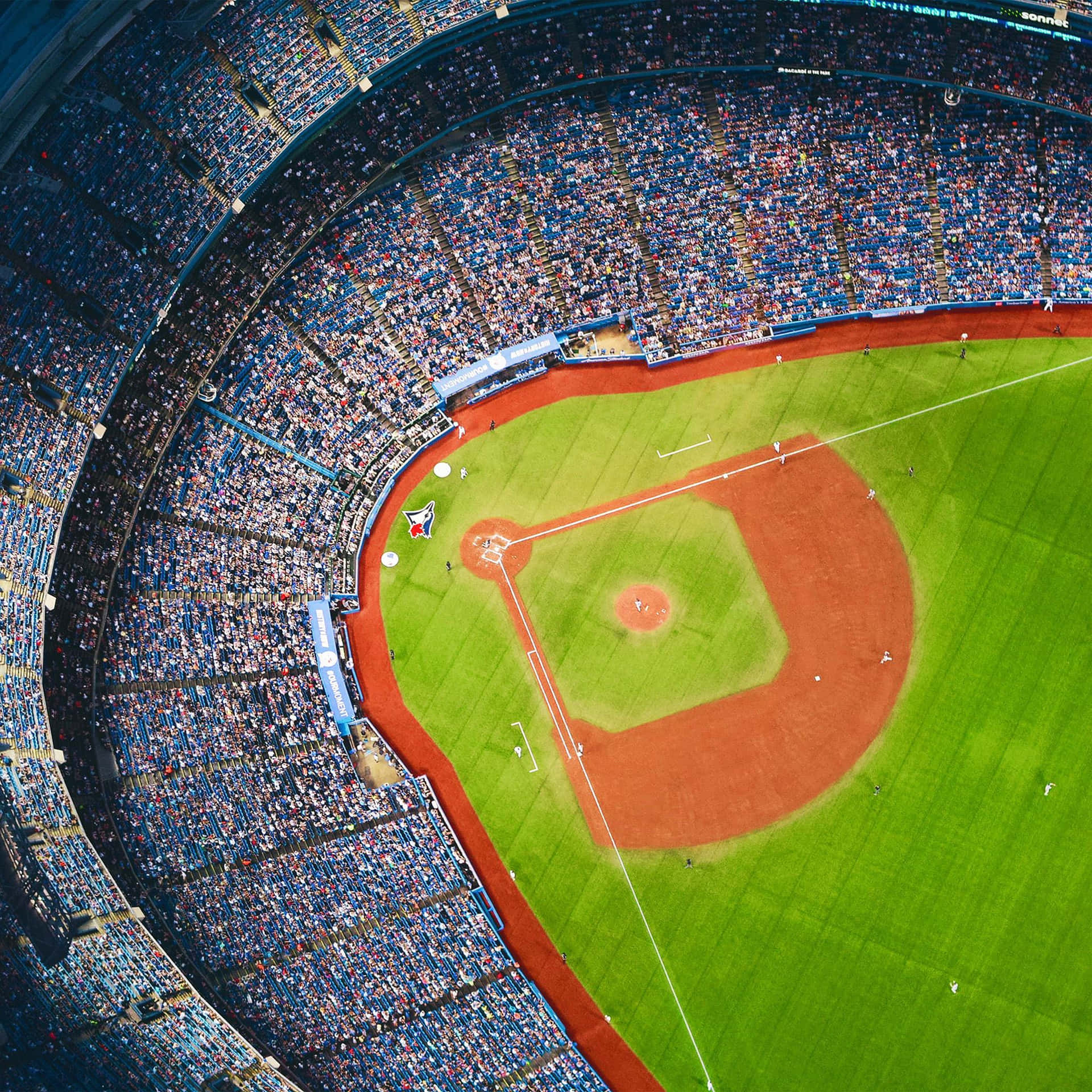 從高空俯瞰一個日間比賽中坐滿觀眾的棒球場。 — MLB 壁紙