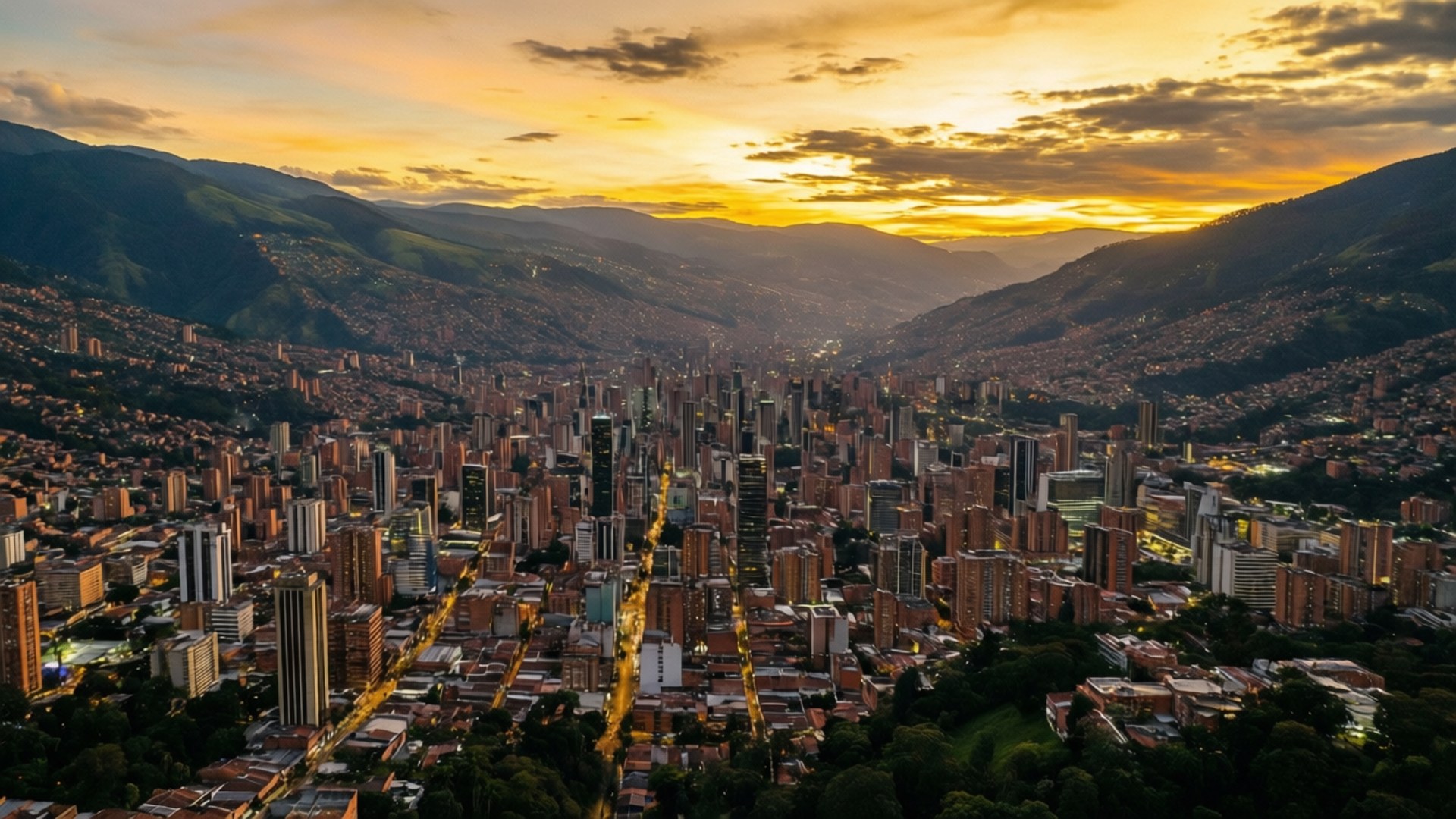 Medellin Sunset Panorama 壁紙 — 黃金日落時分，山谷間群山環抱的廣闊城市鳥瞰圖。