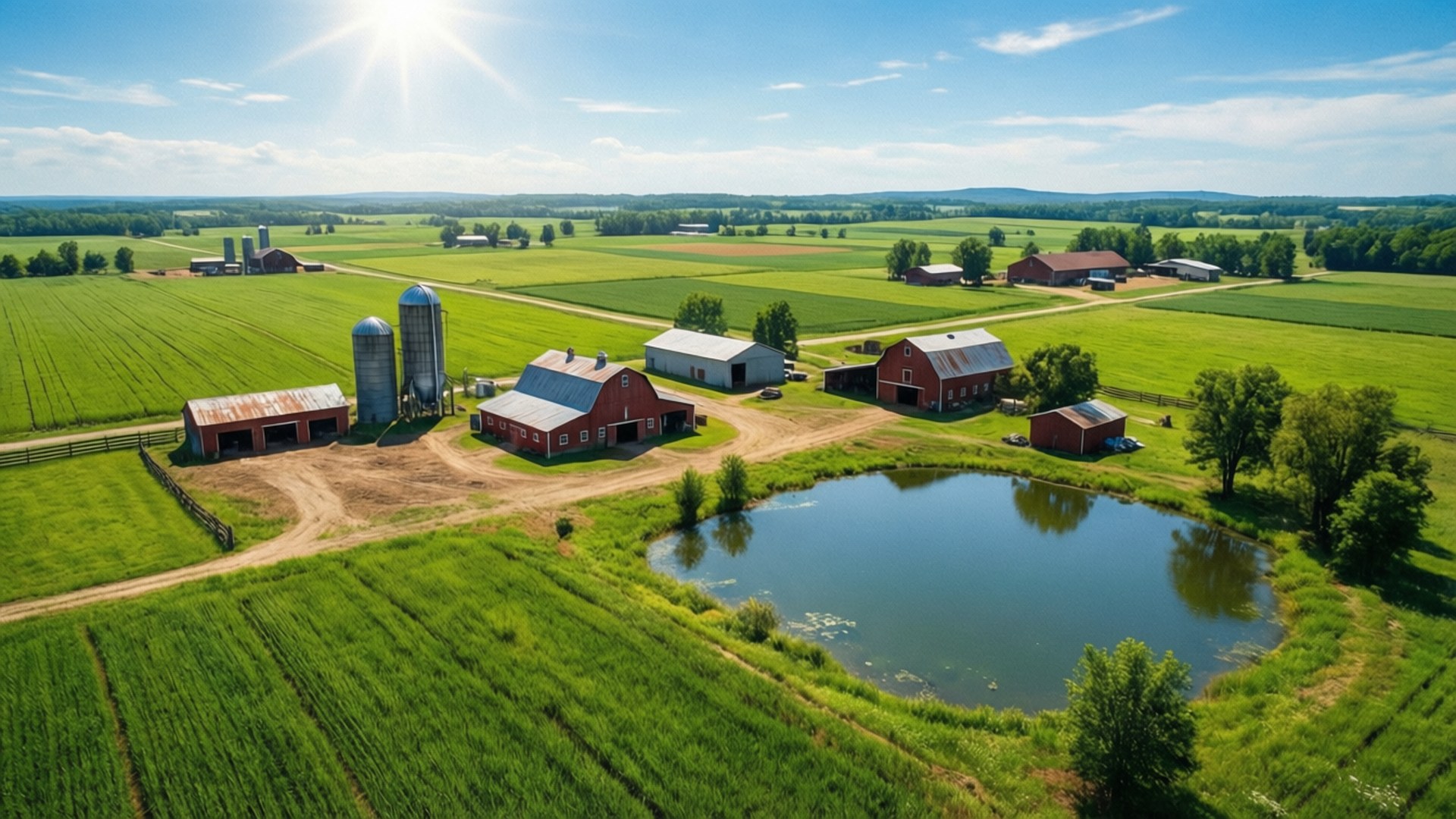 Farming Simulator 桌布 壁紙 — 鳥瞰一個充滿活力的紅色穀倉農場，設有筒倉和池塘，周圍環繞著茂密的綠色田野，在明亮的陽光下。