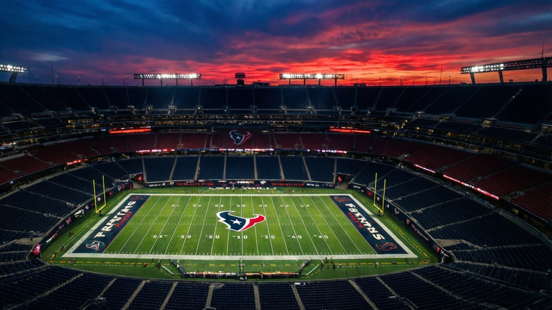 Sunset Over NRG Stadium 壁紙 — 日落時分空無一人的休士頓德州人體育場鳥瞰圖，綠色球場上空有鮮豔的紅橙藍色天空。