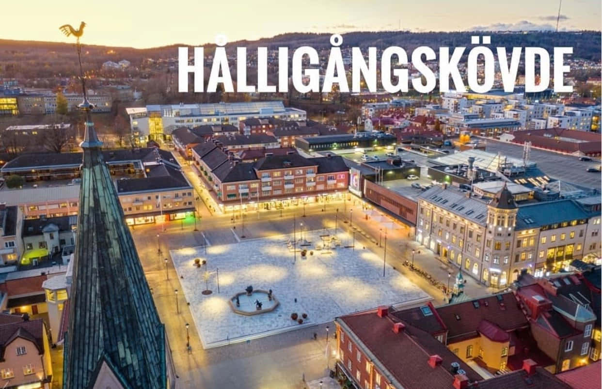 Skövde 桌布 壁紙 — Hålligångskövde 小鎮廣場在黃昏時的鳥瞰圖，地面被雪覆蓋，建築物燈火通明。