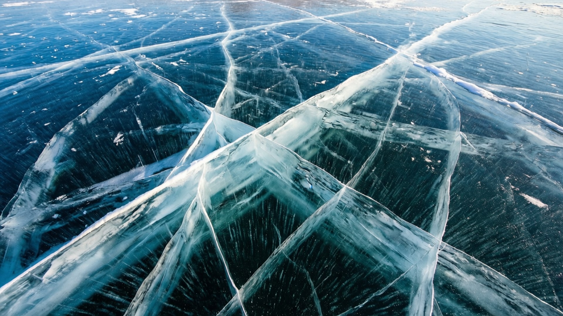 Baikal Ice 壁紙 — 鳥瞰圖：在明亮的陽光下，冰凍的藍色湖泊上形成幾何圖案的複雜冰裂紋。