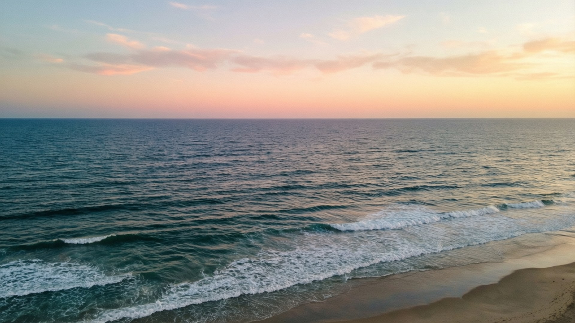 海浪在粉紅橙色日落天空下衝擊沙灘 — 3440X1440 壁紙