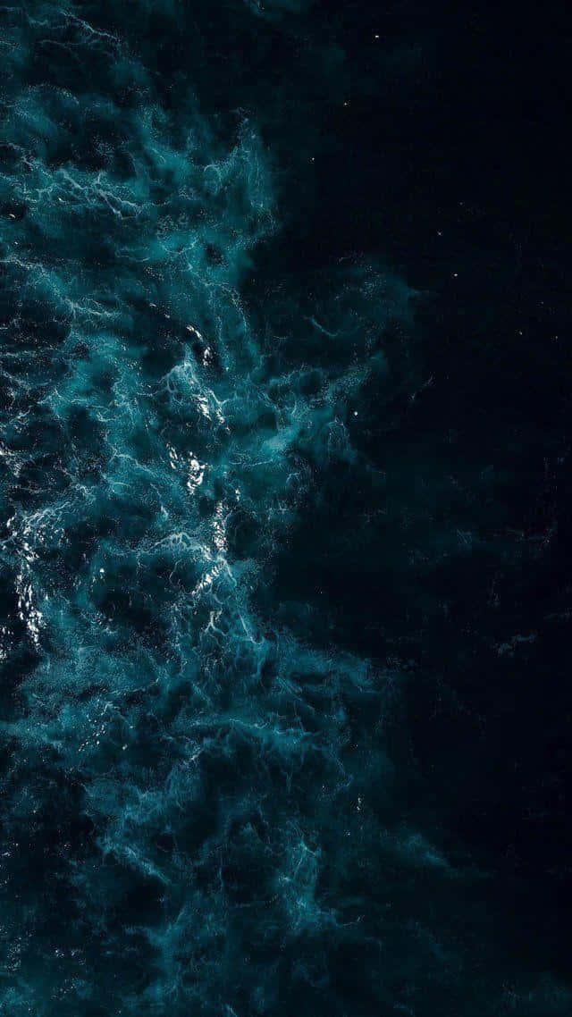  壁紙 — 星空夜晚下，深黑色海水中翻騰的藍綠色海浪的鳥瞰圖。