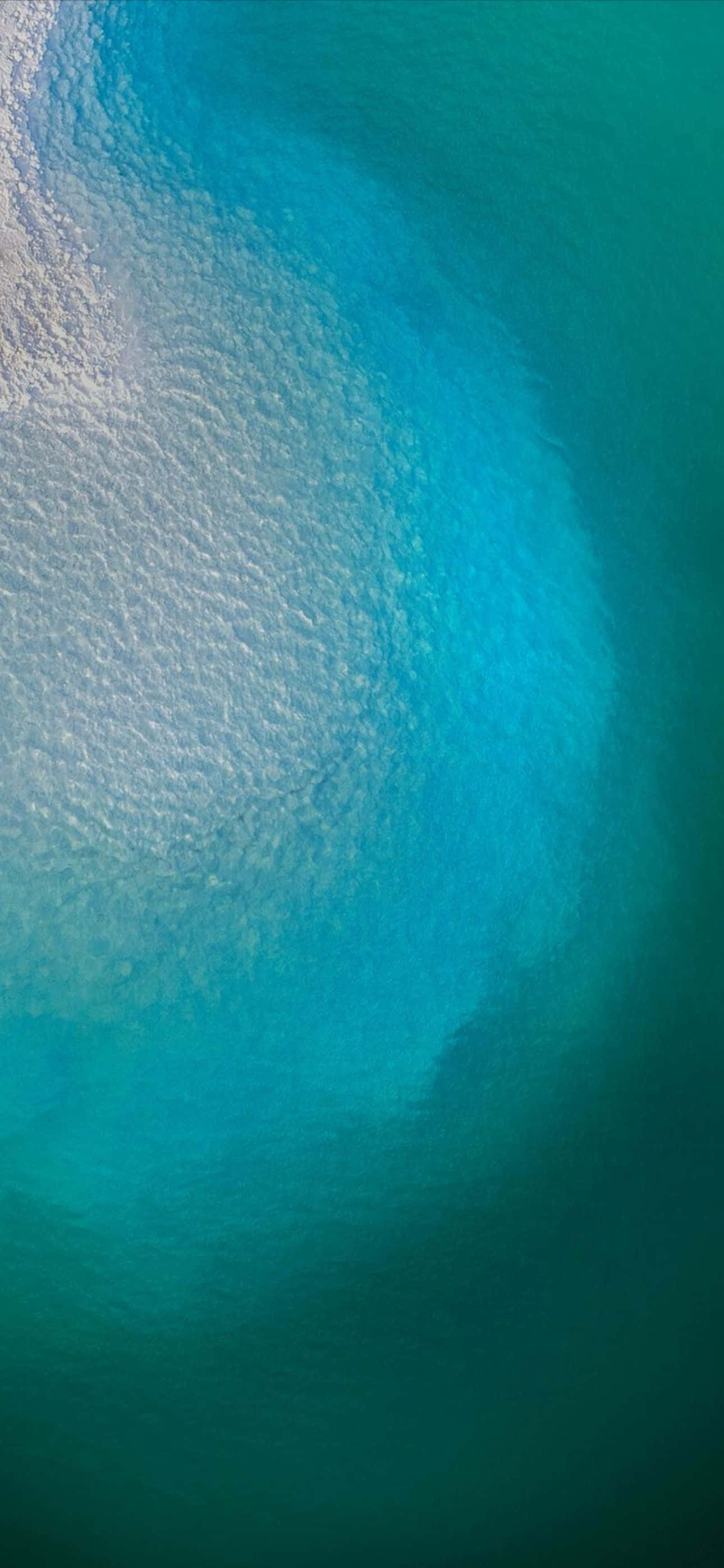 從白色泡沫過渡到深綠松石色水的海洋波浪的航拍視圖。 — iPhone 11 Pro Max 壁紙