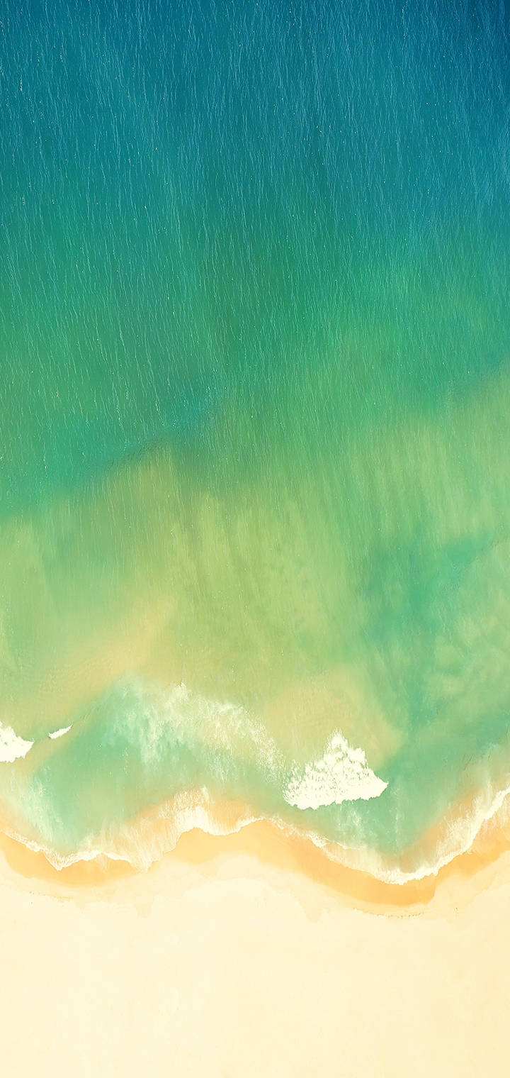 碧綠的海浪從上方沖刷沙灘的景象。 — Realme 壁紙 壁紙