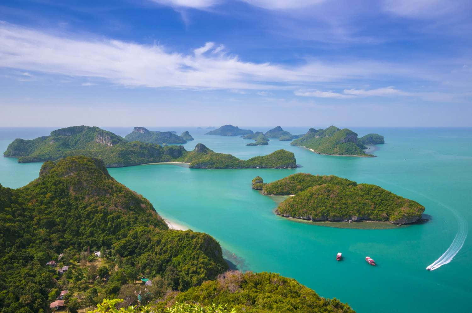  壁紙 — 從高空俯瞰，碧綠色的海水在翠綠島嶼之間蜿蜒流淌，上方是晴朗的藍天和零星的白雲。
