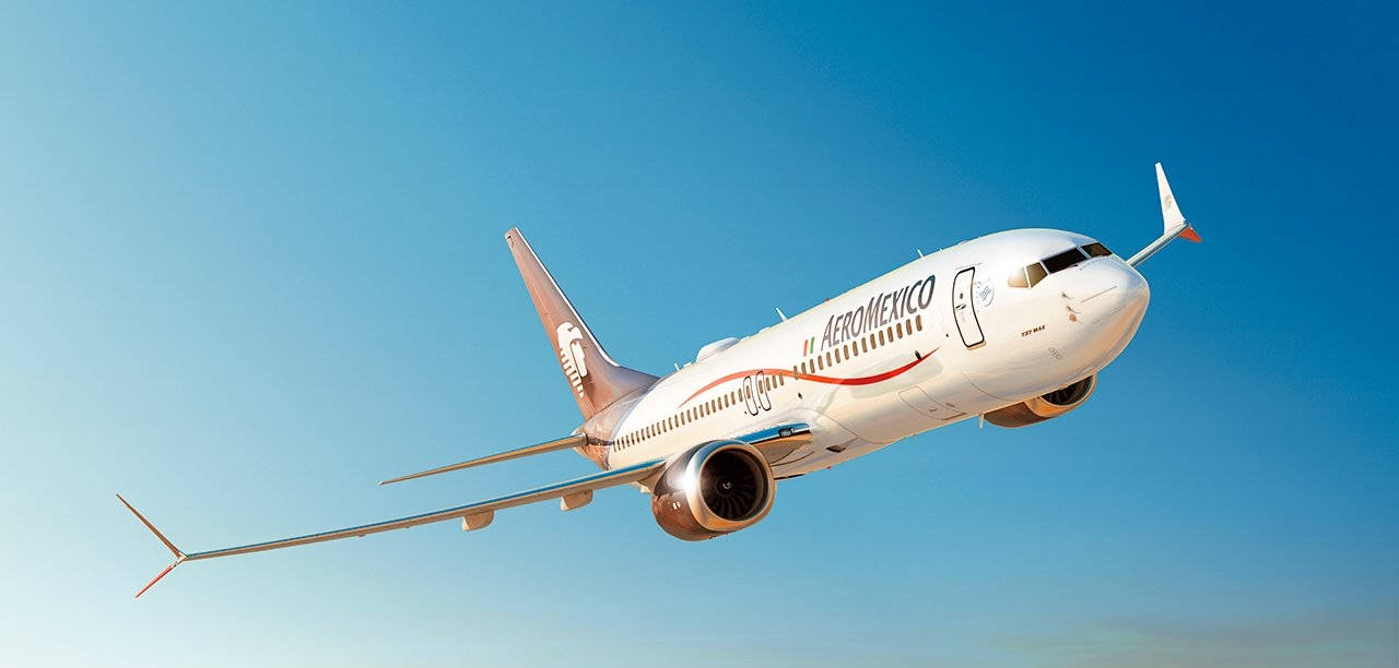 Plane 桌布 壁紙 — Aeromexico 客機在清澈的藍天中翱翔，陽光在其白色機身和紅色尾翼上閃閃發光。