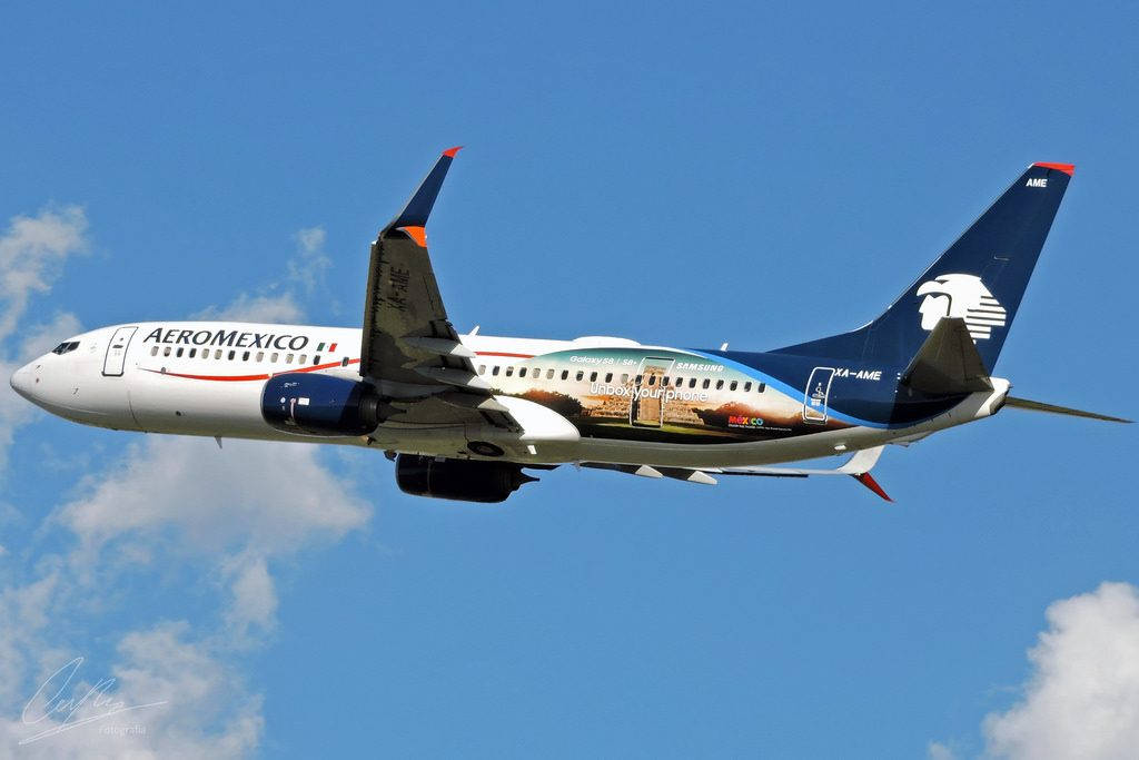Plane 桌布 壁紙 — Aeromexico 波音 737 在明亮的藍天中翱翔，機翼下飄著蓬鬆的白雲。