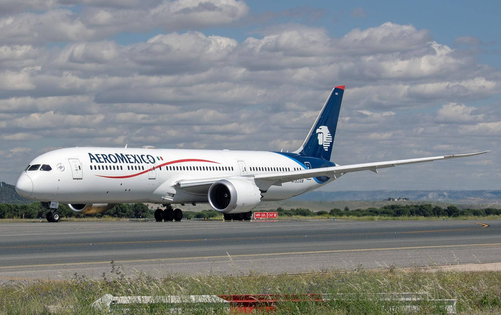 Plane 桌布 壁紙 — Aeromexico 波音 787 夢幻客機在部分多雲的天空和遠山下滑行在跑道上。