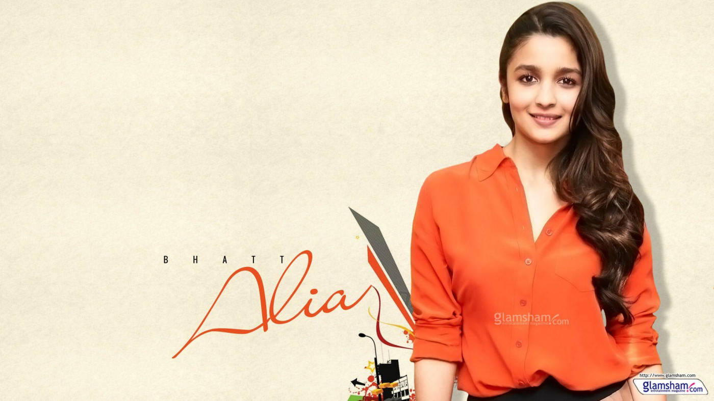Alia Bhatt HD 桌布 壁紙 — Alia Bhatt 穿著亮橙色襯衫，在帶有紋理的米色背景上，搭配風格化文字和圖形元素，溫暖地微笑。