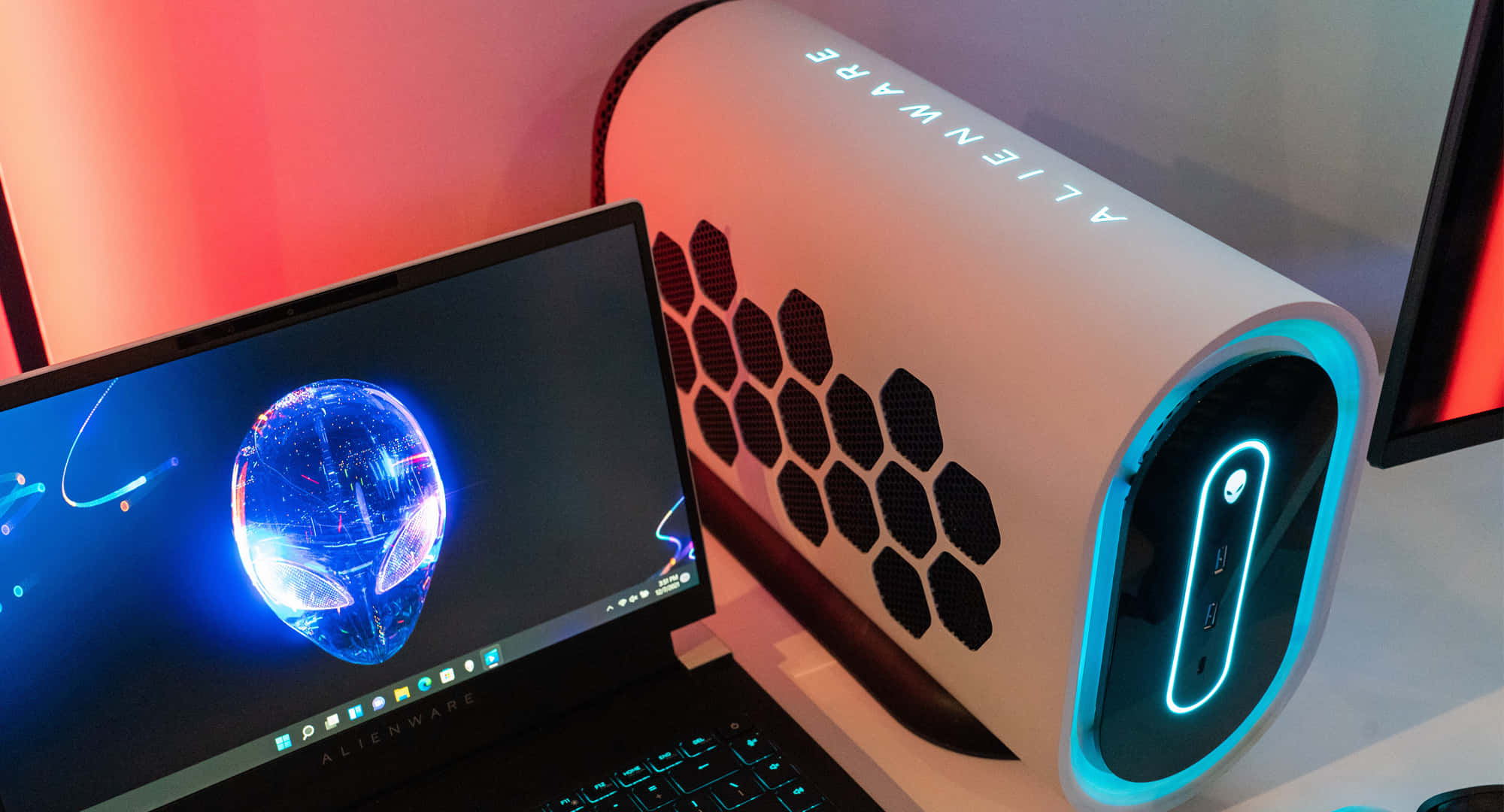 外星人 桌布 壁紙 — Alienware 遊戲筆記型電腦和主機在黑暗背景下發出藍色和紅色霓虹燈光。