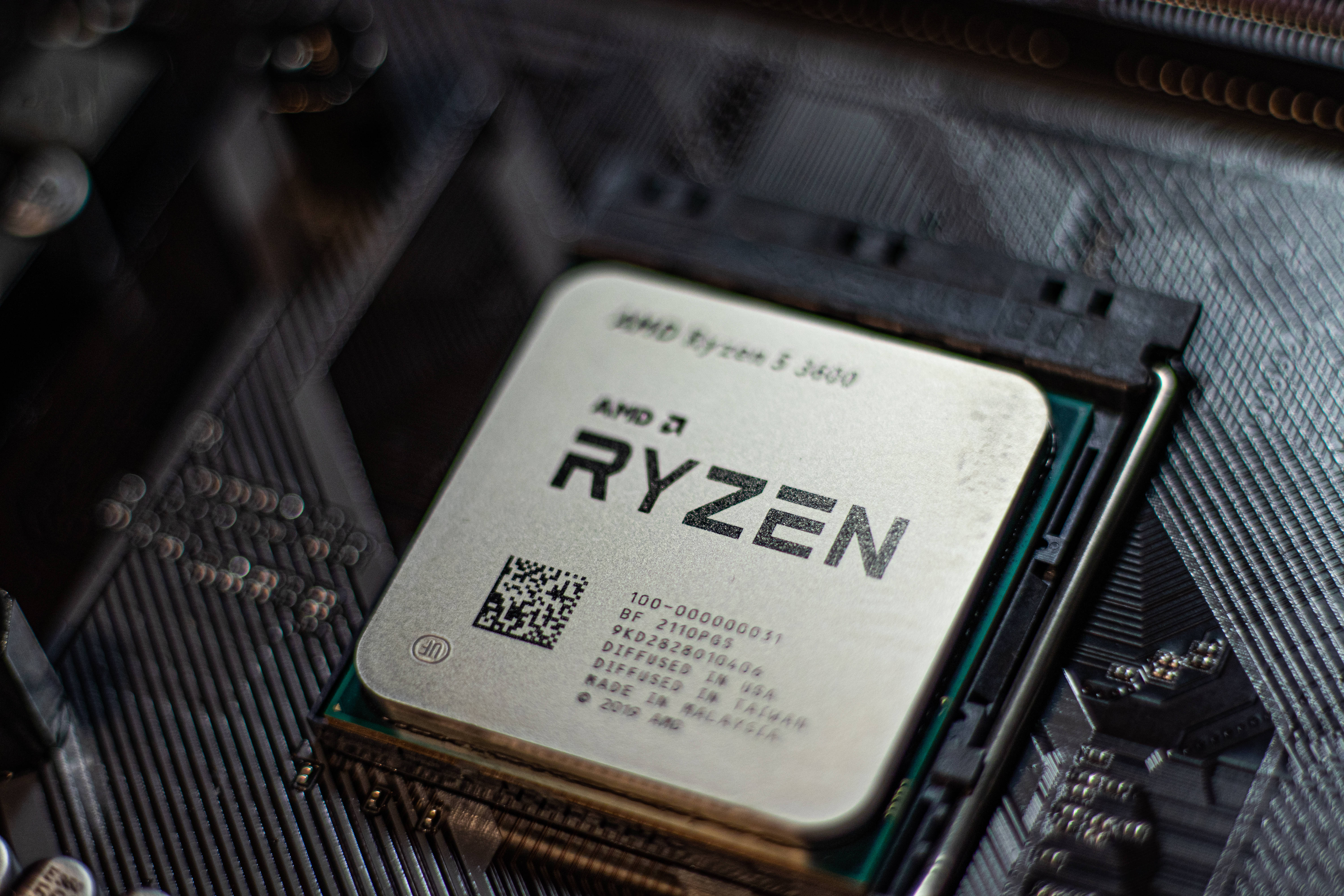 Motherboard 桌布 壁紙 — AMD Ryzen 5 3600 CPU 安裝在主機板上的特寫，可見焊點和電路。