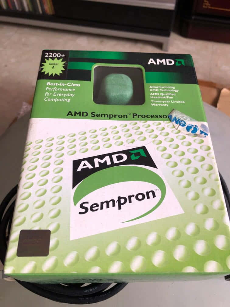 AMD Sempron 處理器盒，綠色和白色設計，窗口內可見 CPU。 — Amd 壁紙