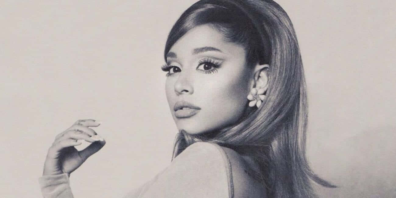  壁紙 — 一幅詳細的鉛筆素描，描繪Ariana Grande在柔和的灰階肖像中，戴著花朵耳環並舉起手。