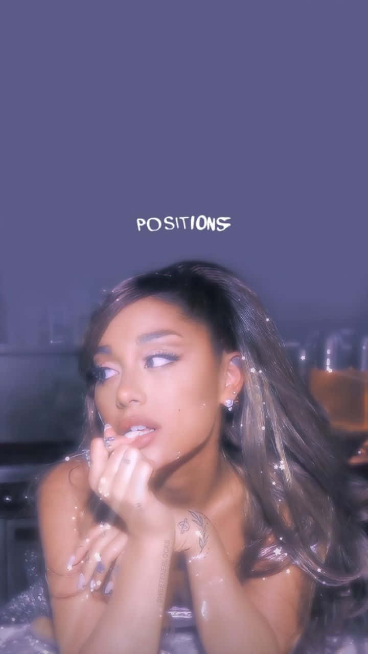  壁紙 — Ariana Grande 在充滿氛圍感的紫色燈光場景中，皮膚上有水滴，上方漂浮著「POSITIONS」字樣。