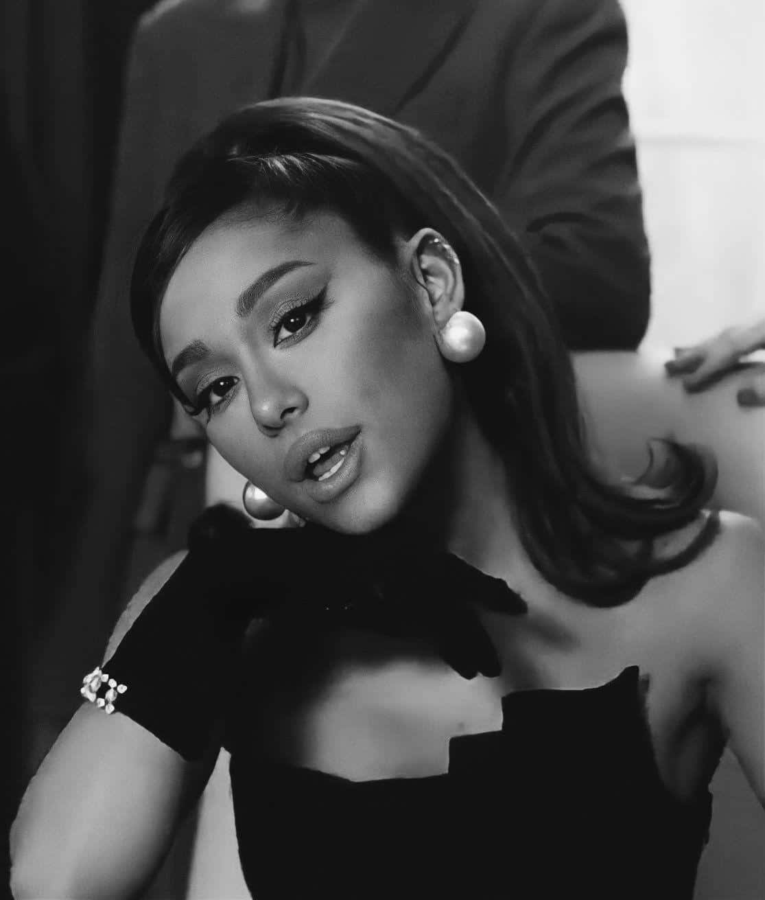  壁紙 — Ariana Grande 在引人注目的黑白肖像中，佩戴珍珠耳環和黑色手套，神情嚴肅。