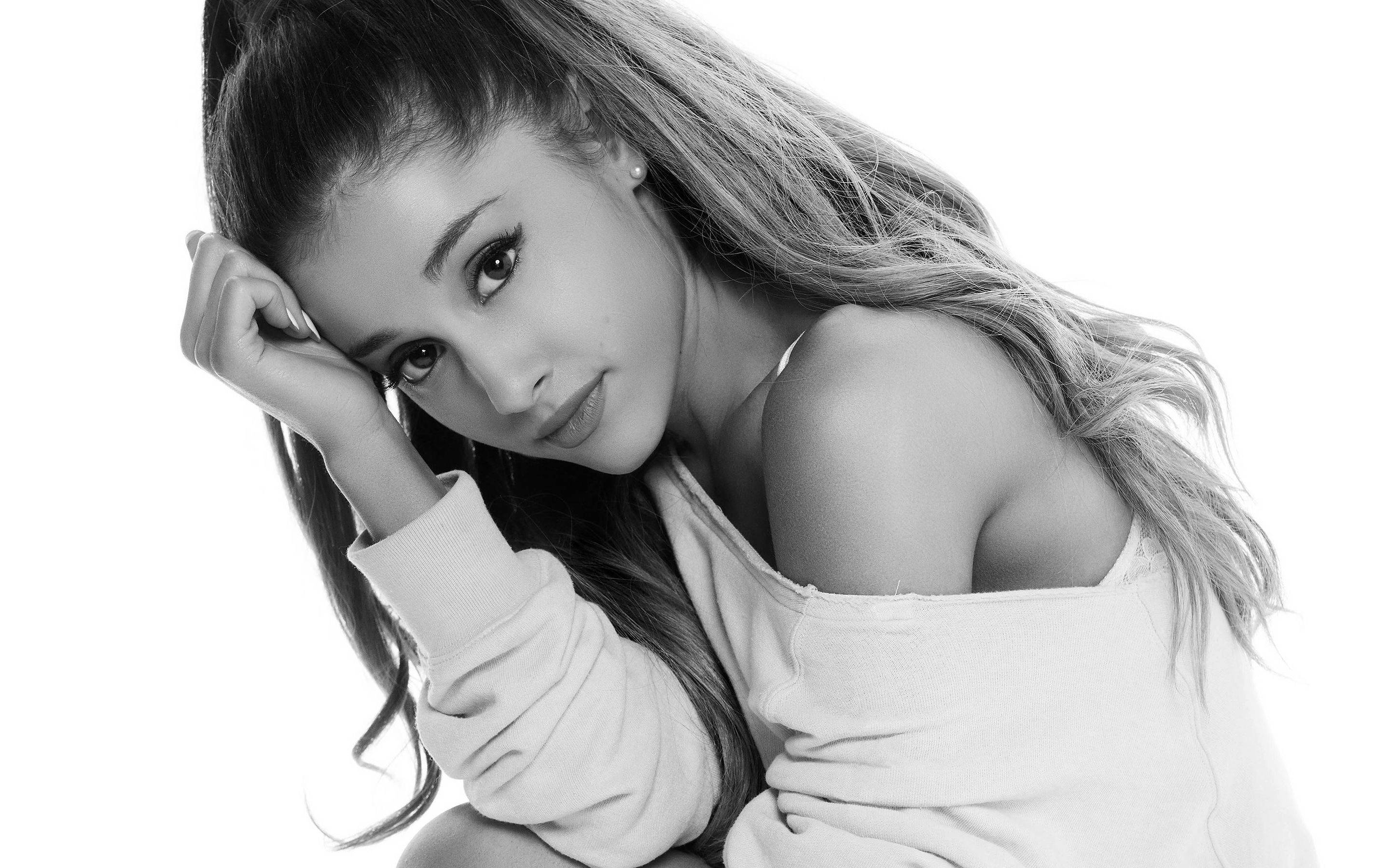 Grande 桌布 壁紙 — Ariana Grande 以黑白風格擺姿勢，手托臉頰，背景為純白色。