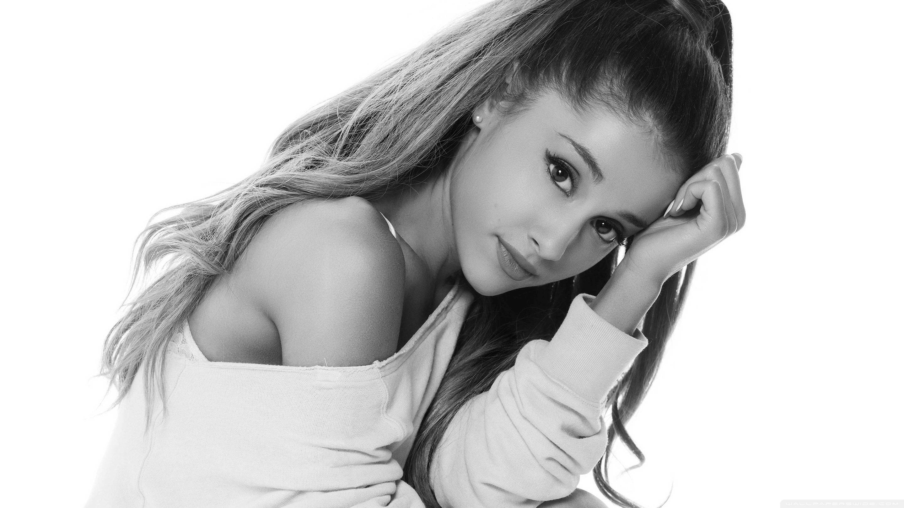 Grande 桌布 壁紙 — Ariana Grande 以黑白風格擺姿勢，手托臉頰，背景為純白色。