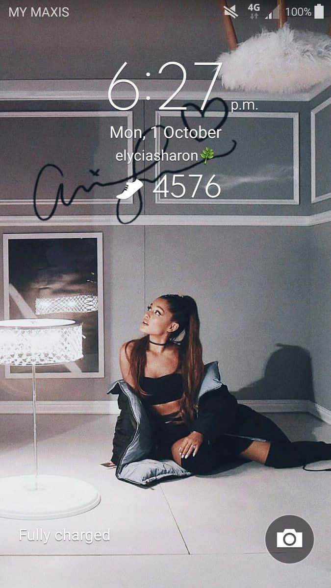 Ariana Grande Aesthetic 桌布 壁紙 — Ariana Grande 優雅地坐在現代房間的地板上，附近有柔和燈光和白色燈。