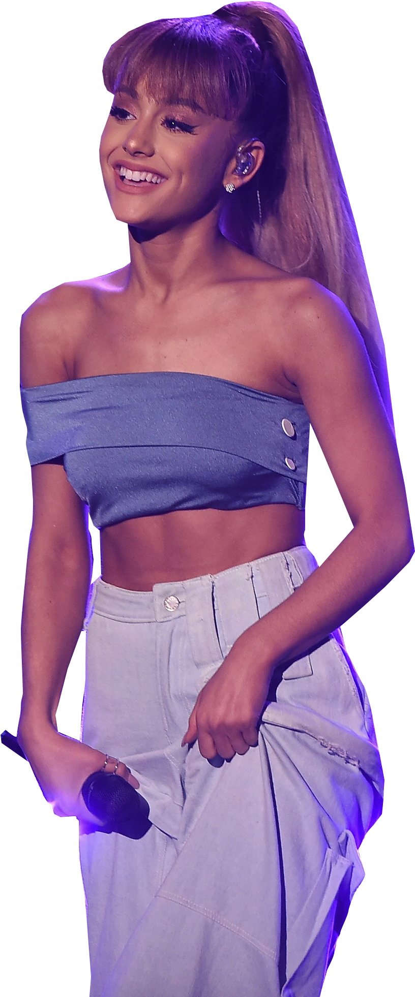 Ariana Grande Cute 桌布 壁紙 — Ariana Grande 在紫色舞台燈光下穿著藍色短版上衣和淺色褲子，燦爛地微笑。