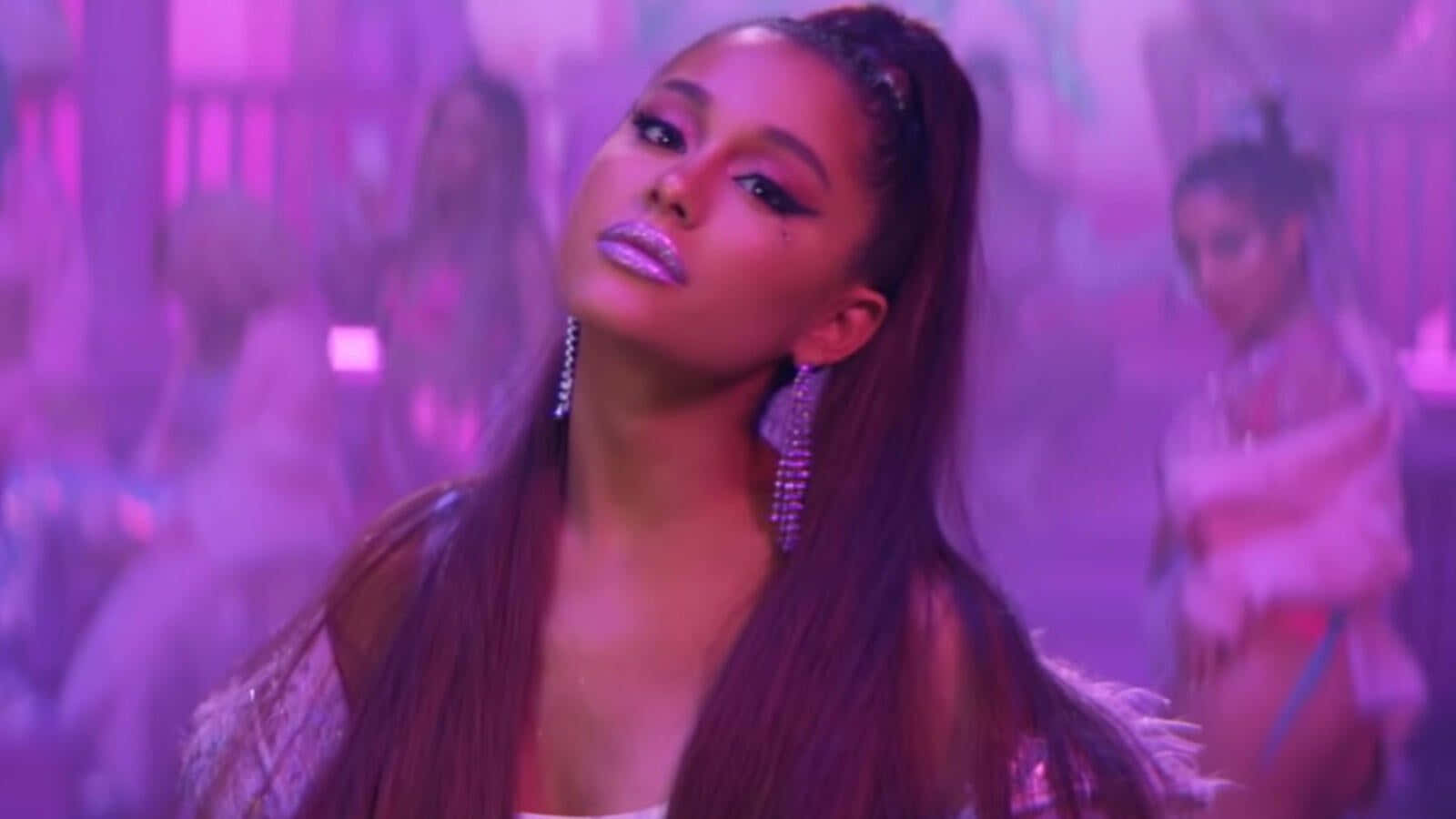 Ariana Grande 7 Rings 桌布 壁紙 — Ariana Grande 在閃爍的紫色燈光場景中，背景有舞者。