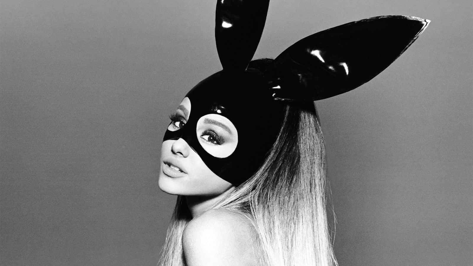 亞莉安娜·格蘭德 桌布 壁紙 — Ariana Grande 戴著亮黑色兔子面具，長長的金色頭髮，背景是純灰色。