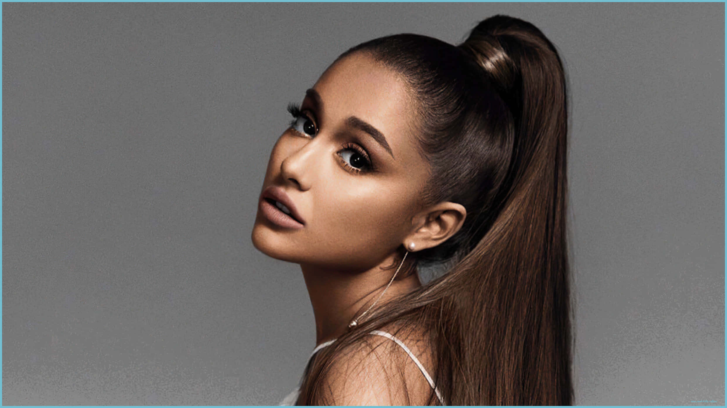 明星 桌布 壁紙 — Ariana Grande 紮著高馬尾，在灰色中性攝影棚背景下，以引人注目的妝容向上凝視。