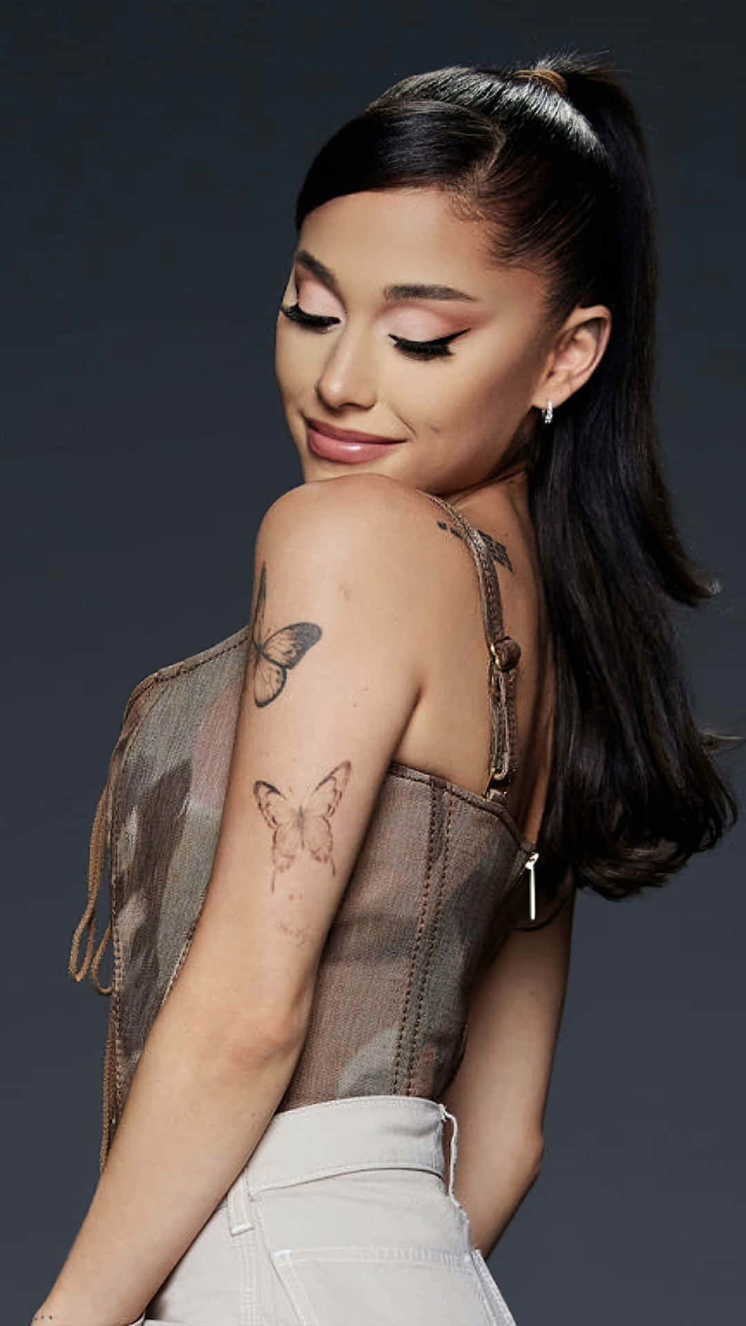 Ariana Grande 在工作室肖像中手臂上有蝴蝶刺青。
