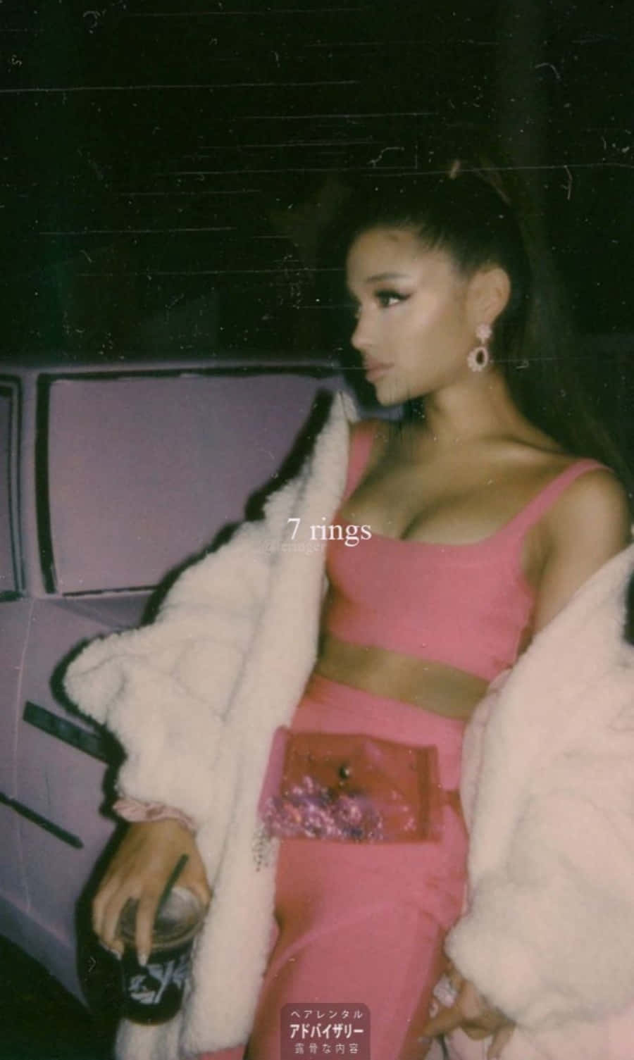 Ariana Grande 7 Rings 桌布 壁紙 — Ariana Grande 身穿粉紅色服裝和白色毛皮大衣，在夜間街燈下，以復古底片顆粒效果，在汽車旁擺姿勢。