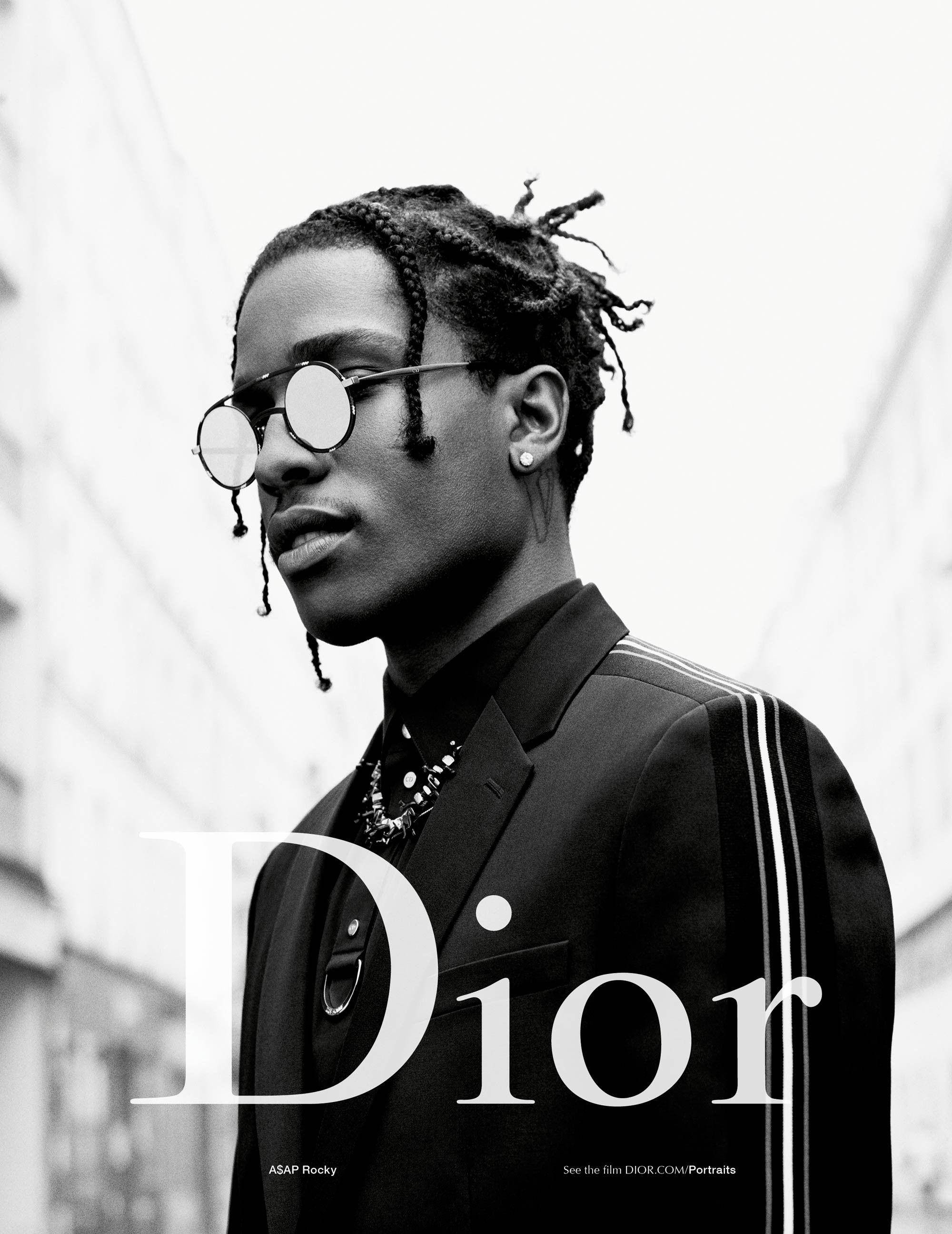 Dior 動態 桌布 壁紙 — ASAP Rocky 身穿訂製西裝和圓形太陽眼鏡的黑色和白色肖像，背景是模糊的城市景觀。