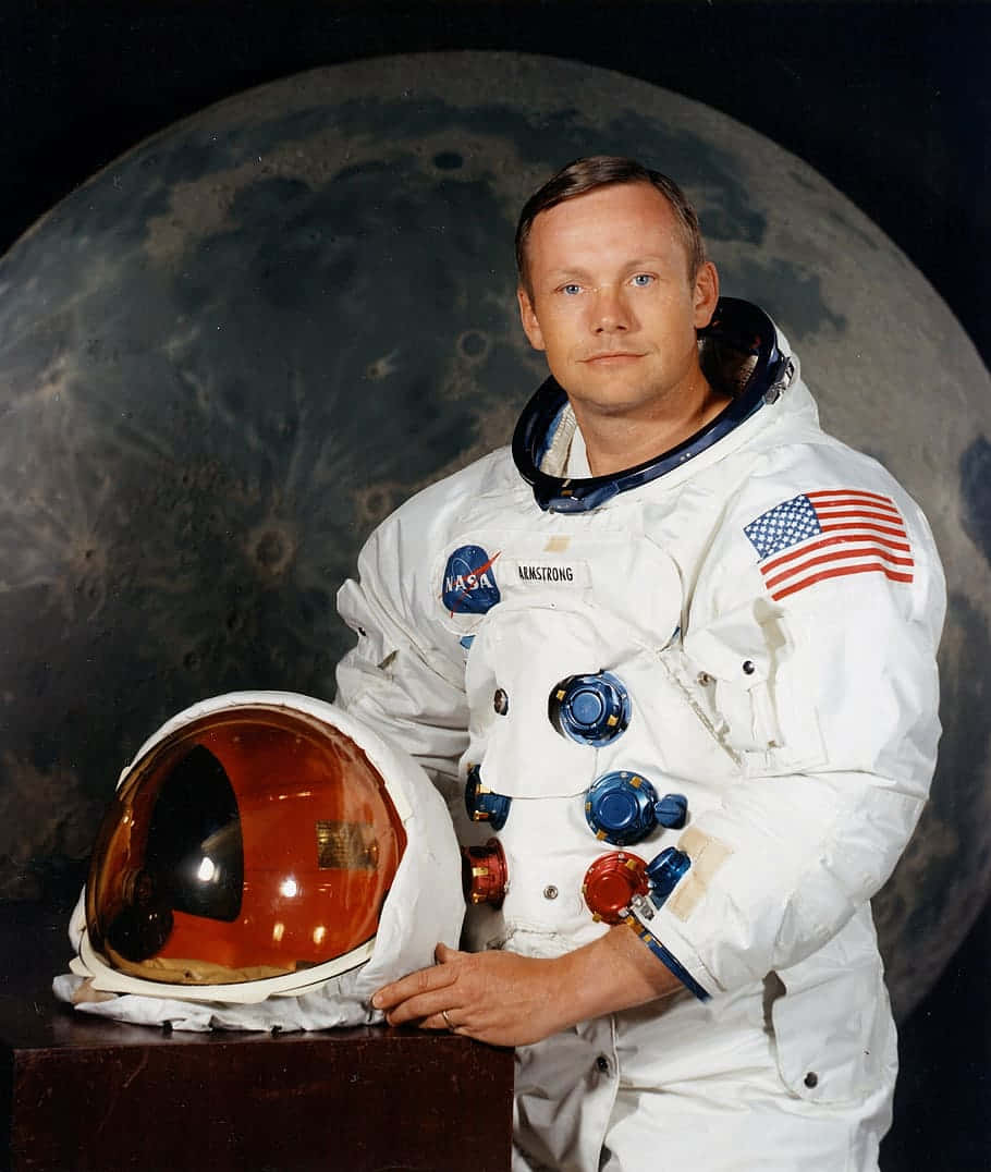 Neil Armstrong 桌布 壁紙 — 太空人尼爾·阿姆斯壯身穿白色太空衣，站在大型月球背景前，手持頭盔。