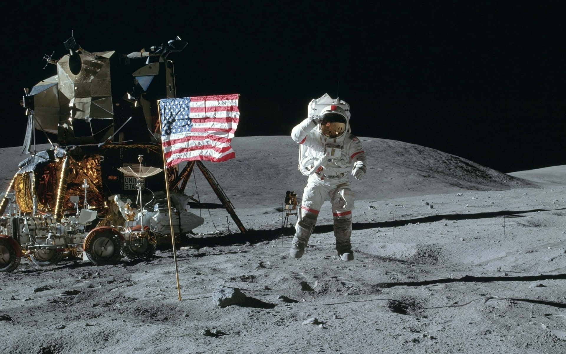 Neil Armstrong 桌布 壁紙 — 一名太空人站在月球上，旁邊是月球登陸艙，美國國旗插在灰色的風化層中，背景是黑色的天空。