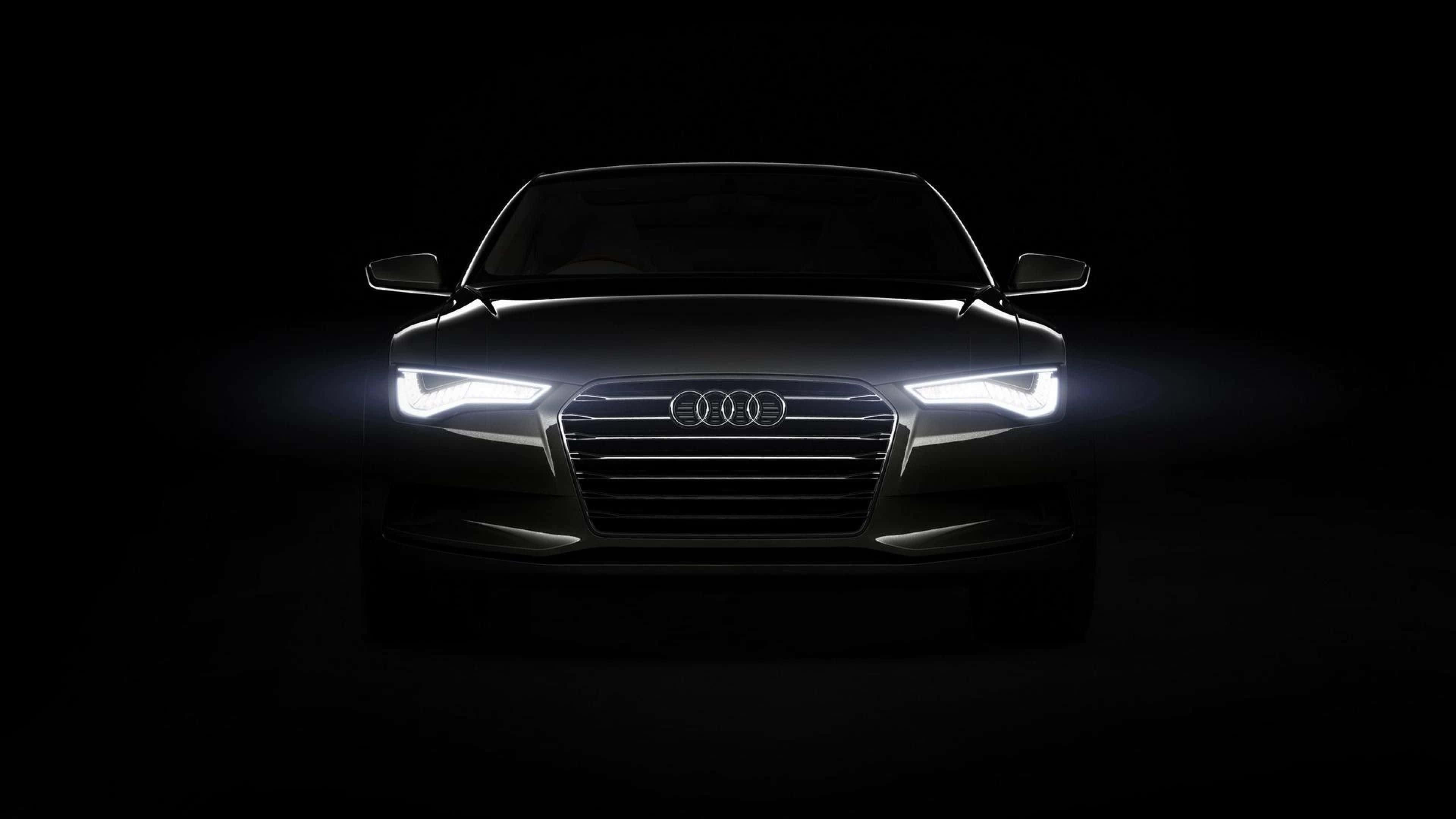 Audi A5 桌布 壁紙 — Audi 車頭被銳利的白色頭燈照亮，背景漆黑一片。