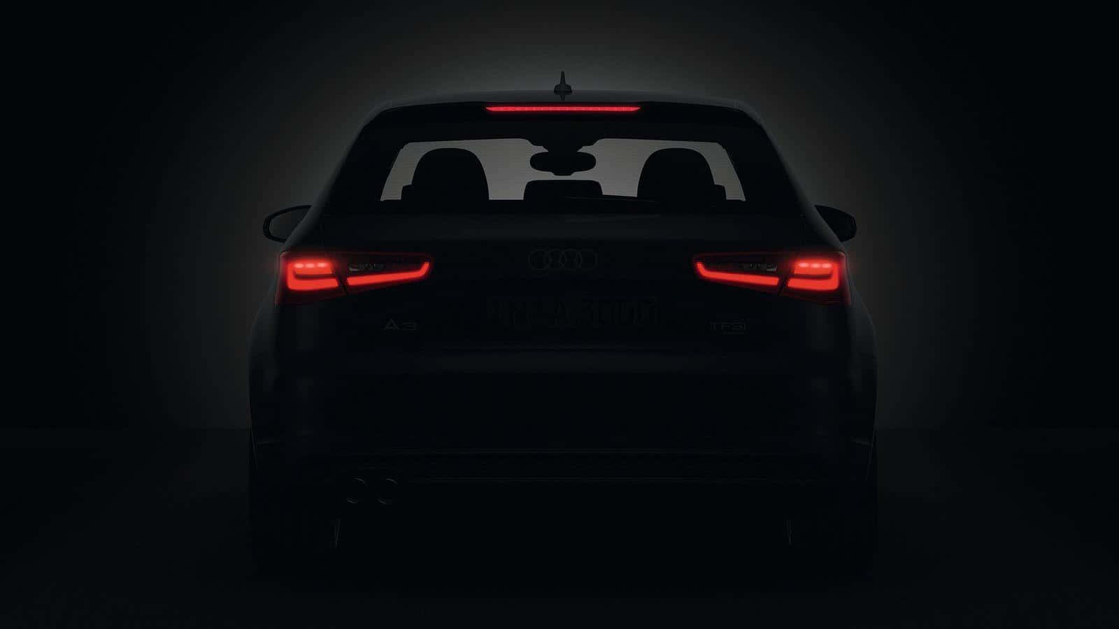 Audi A3 桌布 壁紙 — 奧迪汽車後視圖，紅色尾燈在黑暗工作室背景中發光。