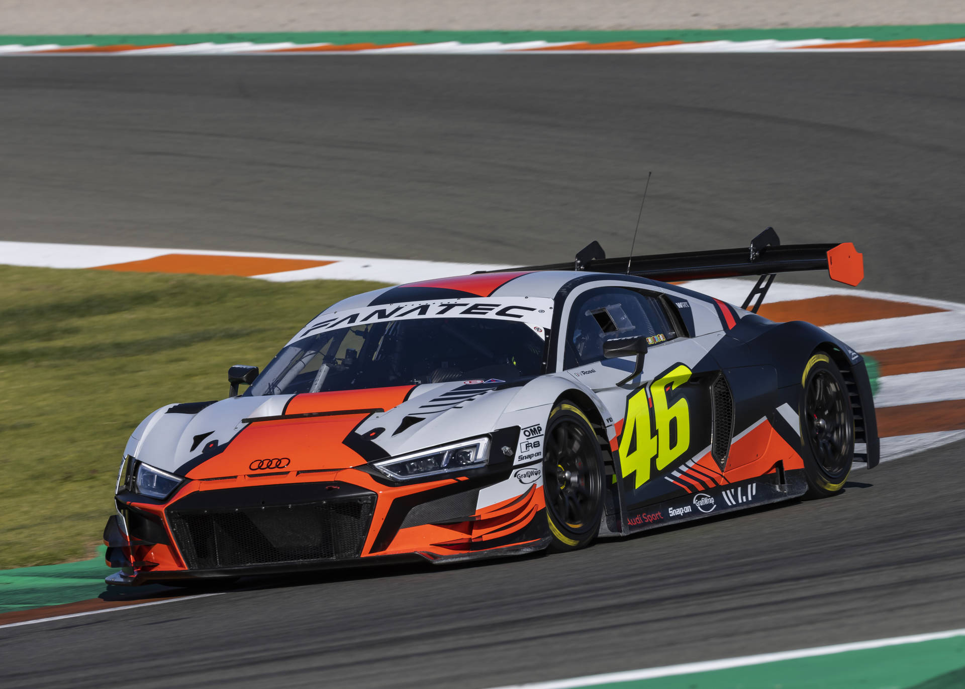 Audi 賽車 46 號在日落時分的賽道上過彎。 — F1 壁紙