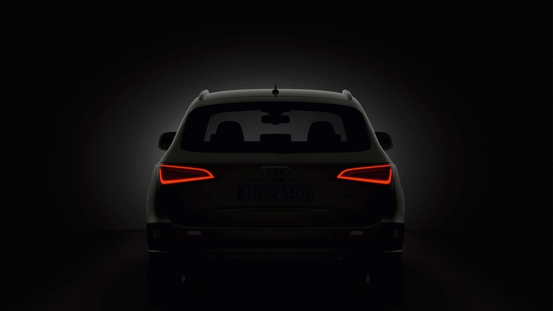 Audi Sq5 桌布 壁紙 — Audi SUV 尾部輪廓，紅色尾燈在黑暗工作室背景中發光。