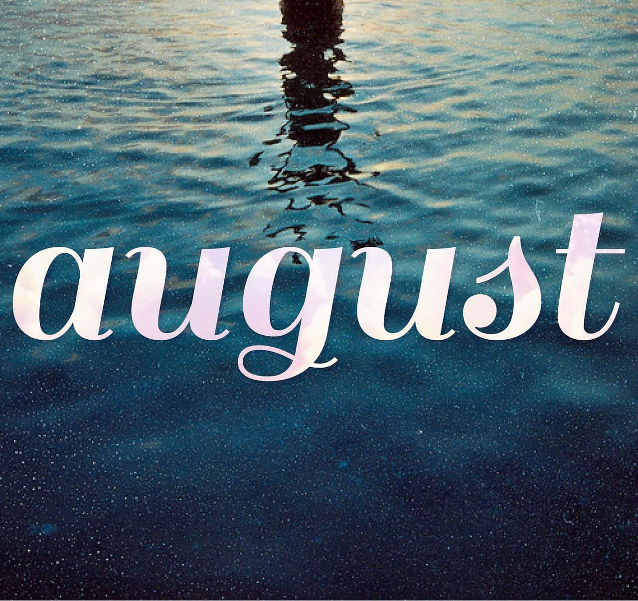August 桌布 壁紙 — 「august」這個字漂浮在深藍色的水中，上面有一個人的倒影泛起漣漪。