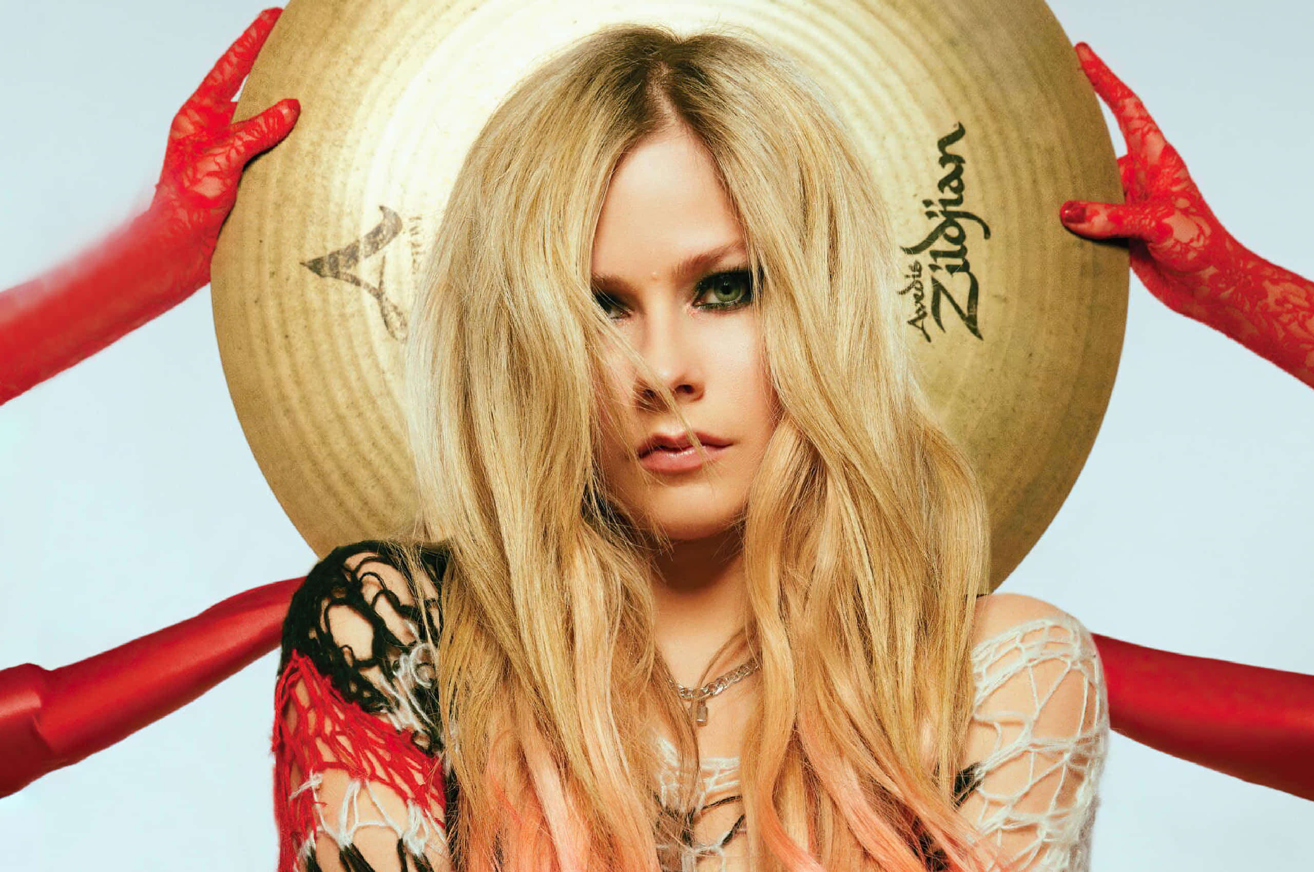 艾薇兒·拉維尼 桌布 壁紙 — Avril Lavigne 穿著蕾絲服裝和紅色手套，將一個大型 Zildjian 鈸舉在頭後，眼神專注。