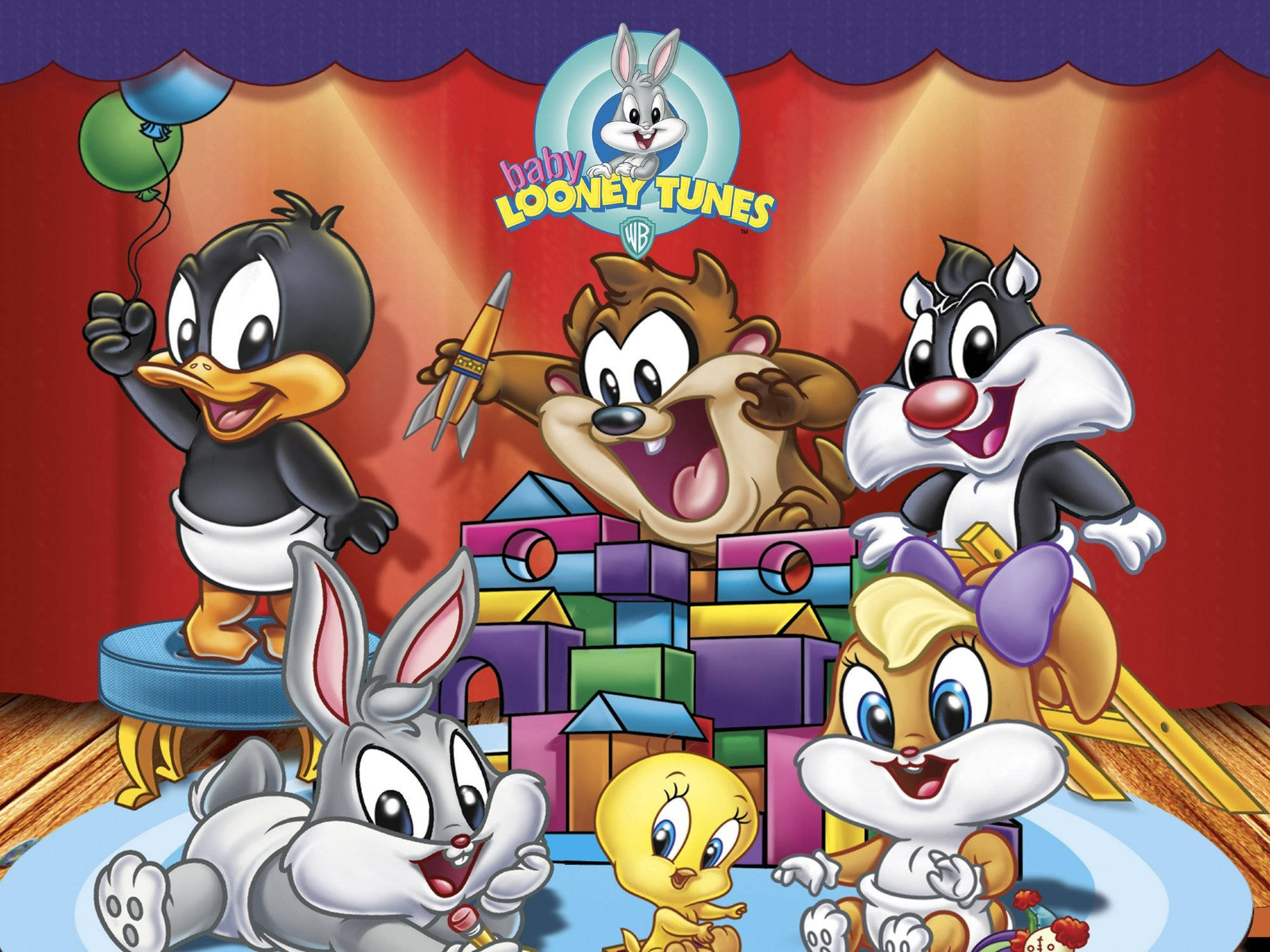 tunes 桌布 壁紙 — Baby Looney Tunes 角色在色彩繽紛的舞台上，在溫暖的聚光燈下，愉快地玩著氣球和玩具積木。