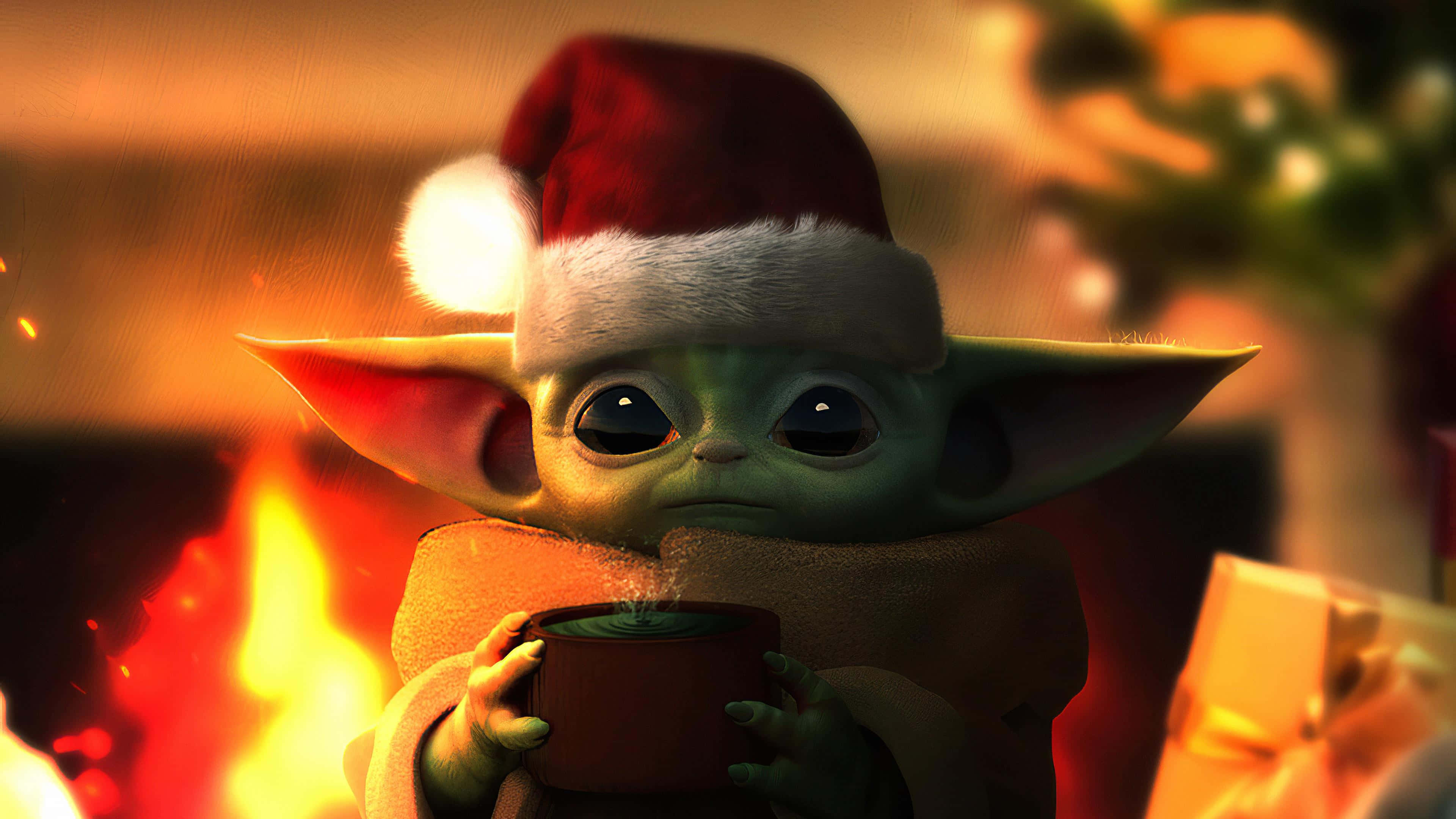 Baby Yoda Cartoon 桌布 壁紙 — Baby Yoda 戴著聖誕帽，在噼啪作響的壁爐旁邊拿著一個冒煙的杯子，營造出溫馨的節日氛圍。