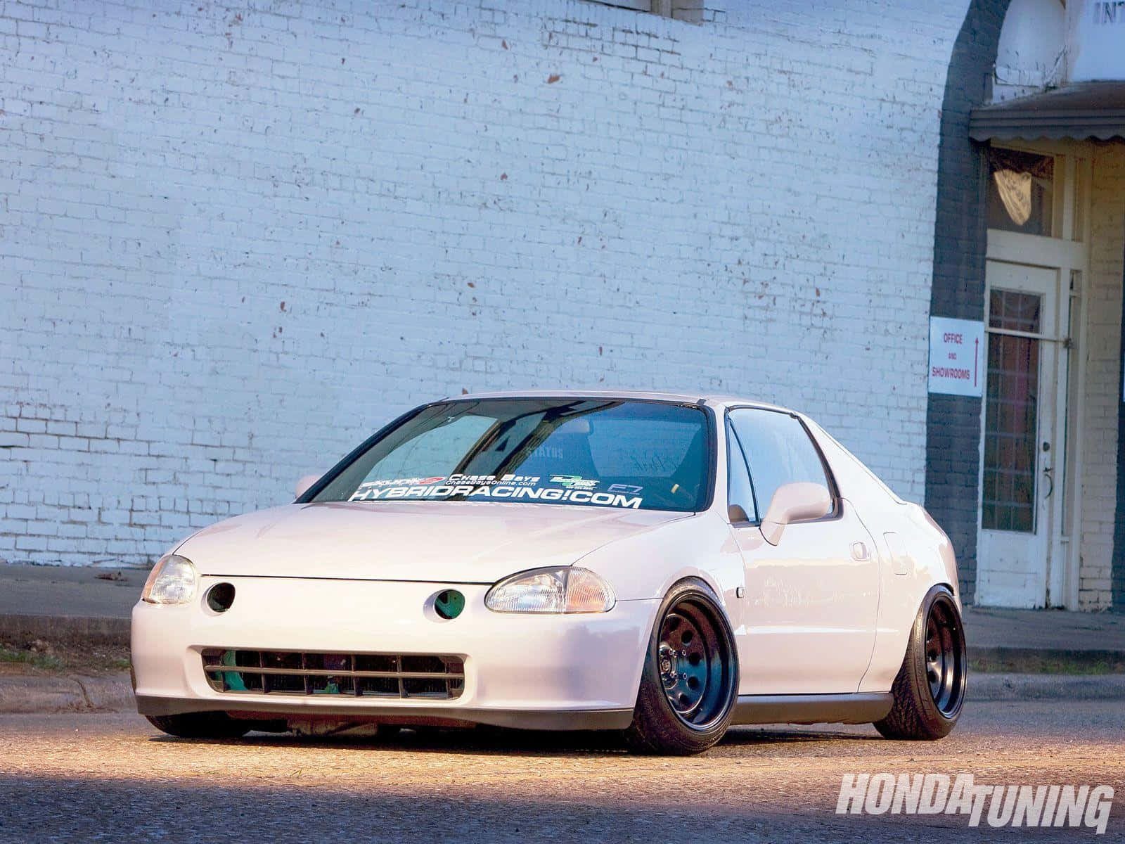 Honda Civic Del Sol 桌布 壁紙 — 一輛白色本田Del Sol跑車，配備訂製藍色輪圈，停泊在陽光普照的街道上，旁邊是白色磚牆。