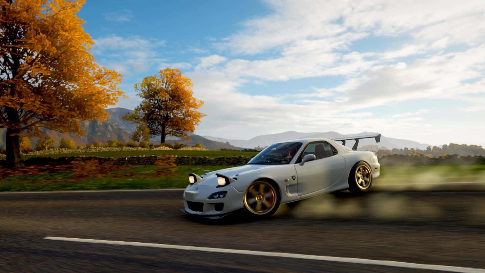  壁紙 — 一輛白色馬自達RX-7在部分多雲的天空下，沿著兩旁金色秋樹的鄉村道路飛馳。