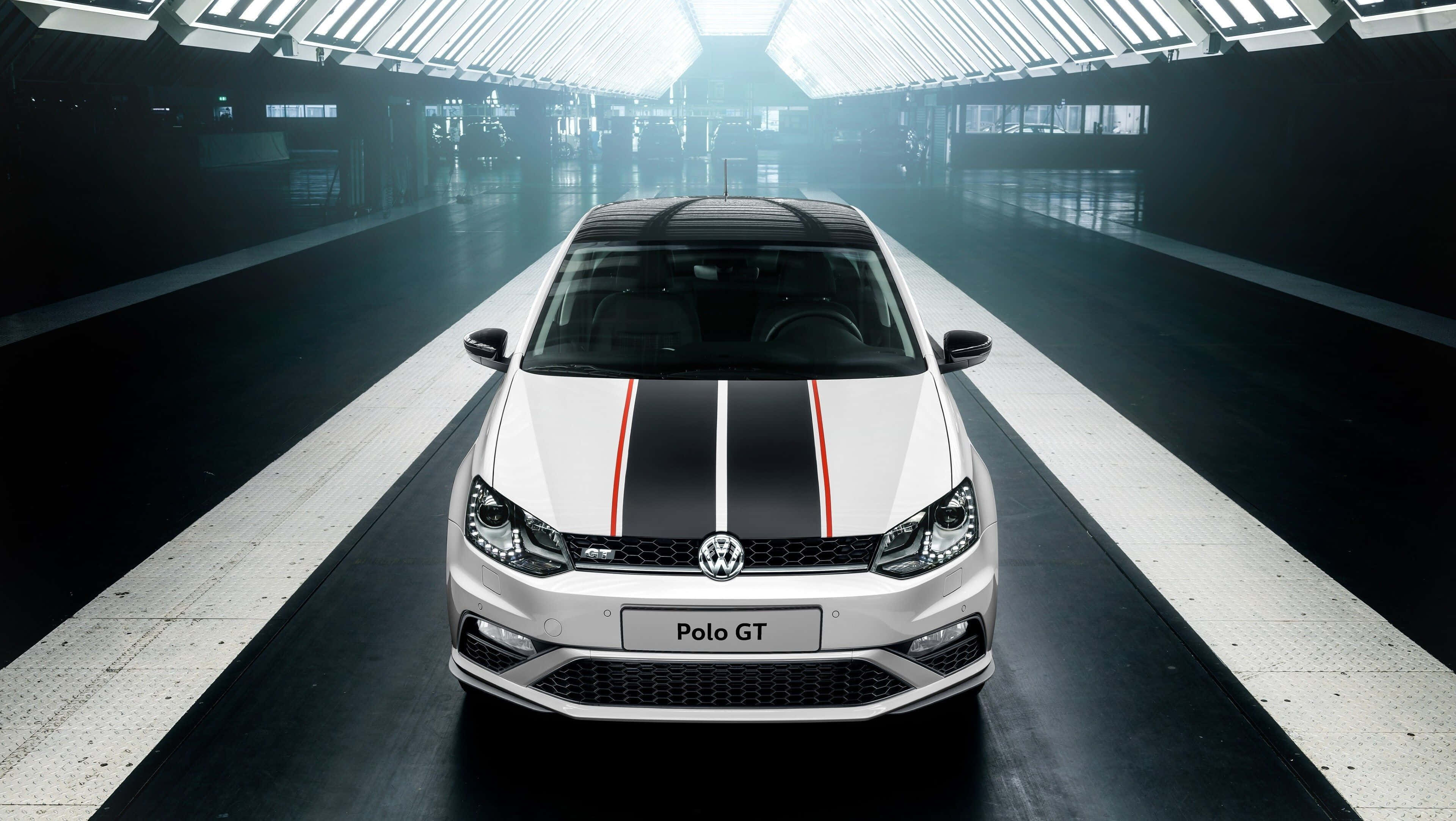 Volkswagen Polo 桌布 壁紙 — 一輛帶有黑色和紅色賽車條紋的白色 Volkswagen Polo GT 位於時尚現代、頂部照明明亮的隧道中央。