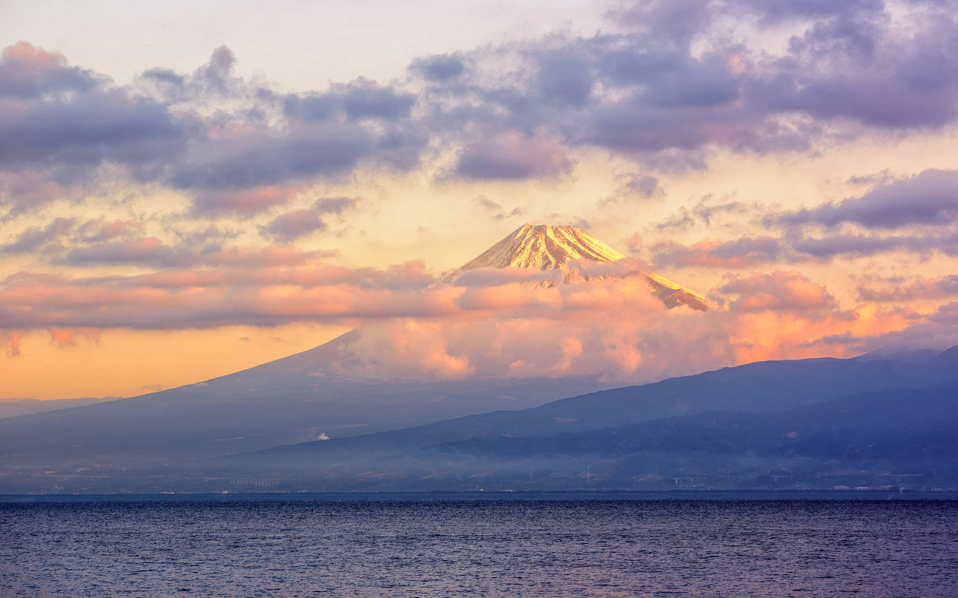 日落時的富士山，雪峰和色彩斑斕的雲彩，下方是平靜的海洋 — 富士山 壁紙