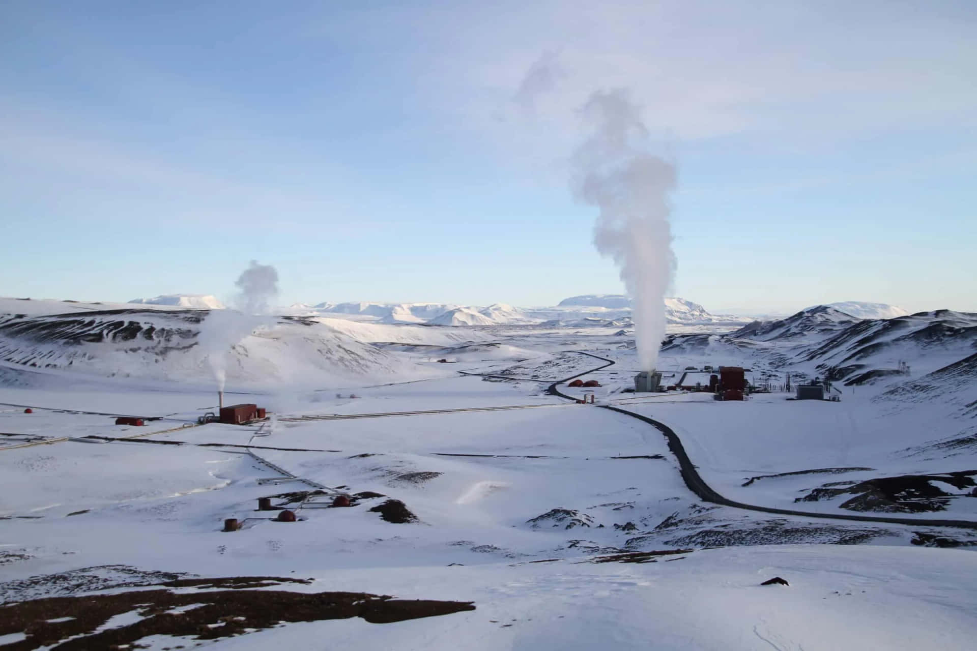  壁紙 — 白雪覆蓋的冰島風景，地熱發電廠在清澈的藍天下排放蒸汽。