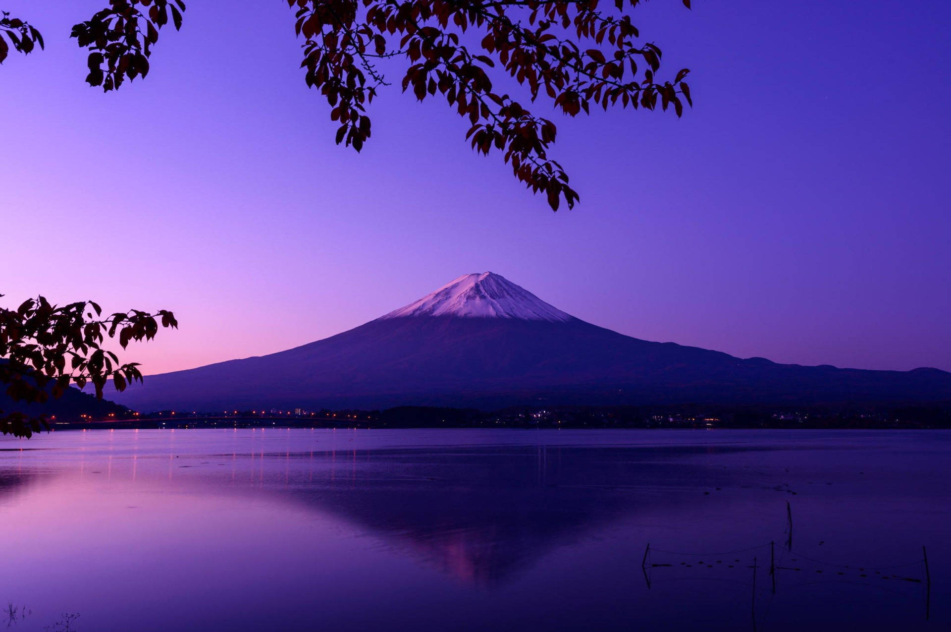 暮色中的富士山倒映在寧靜的湖面上，秋葉環繞著景色。 — 富士山 壁紙