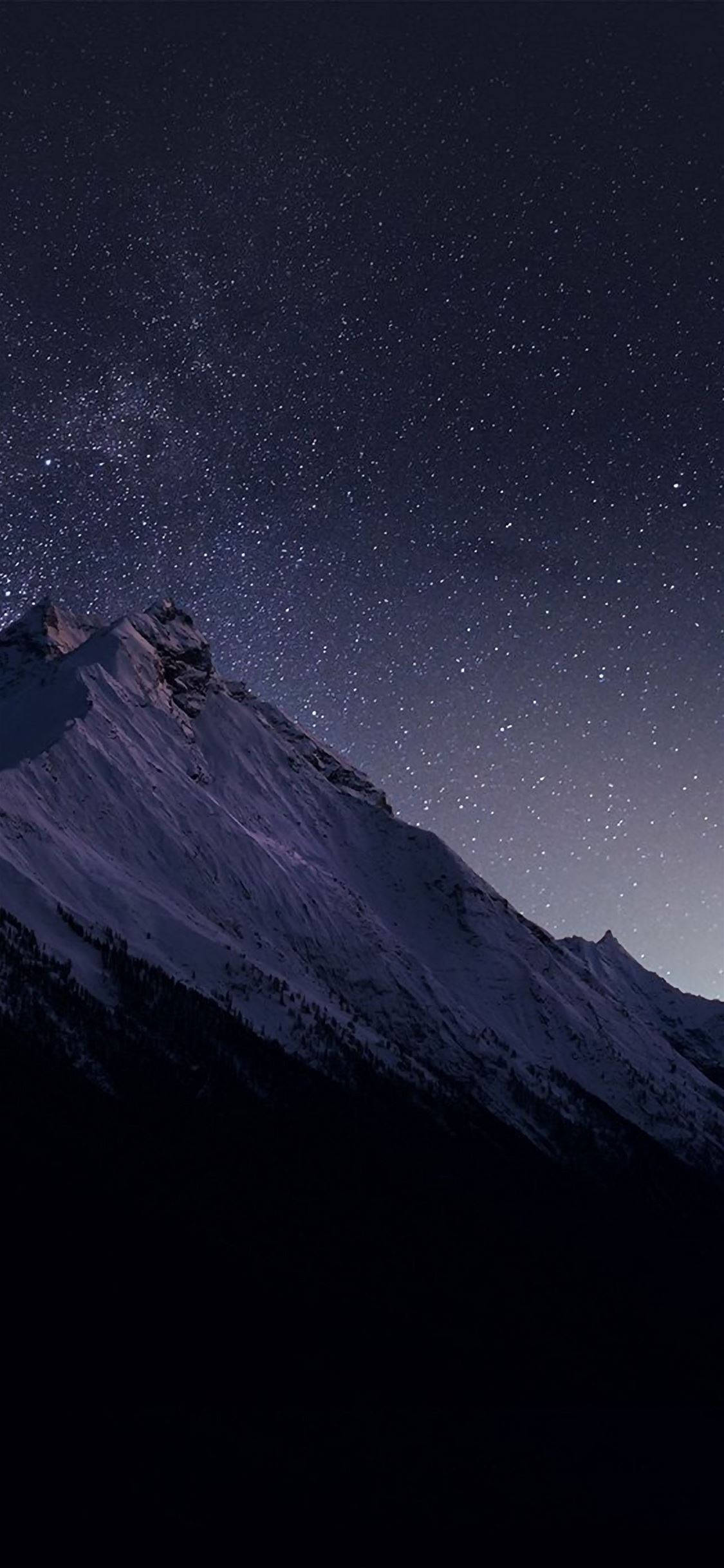 iPhone 桌布 壁紙 — 白雪覆蓋的山峰在密集星野下聳立，銀河在上方閃耀。